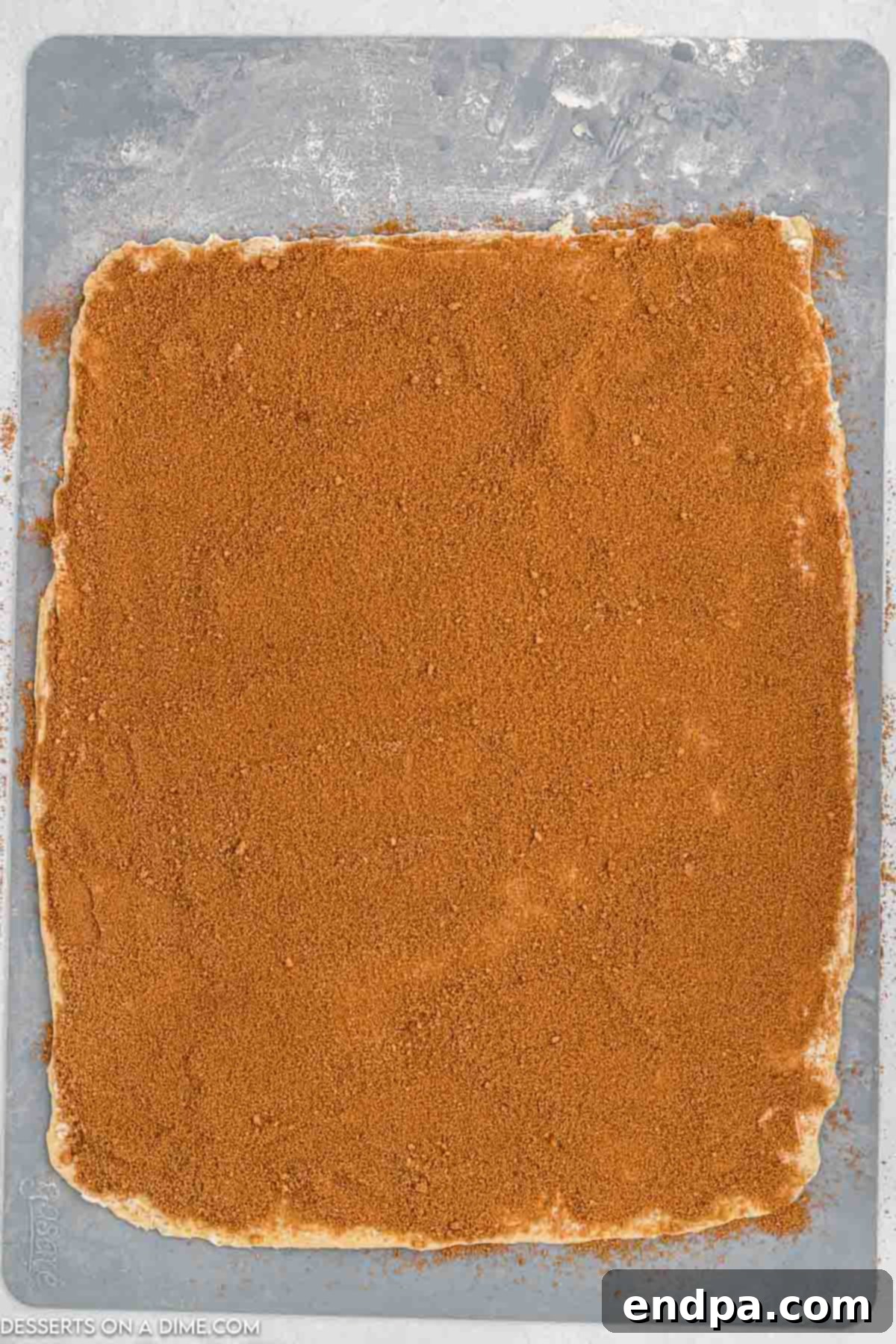 Crafting Perfect Cinnabon Cinnamon Rolls 8 Softened butter spread evenly over the rolled-out dough, topped with a generous sprinkle of cinnamon sugar mixture.