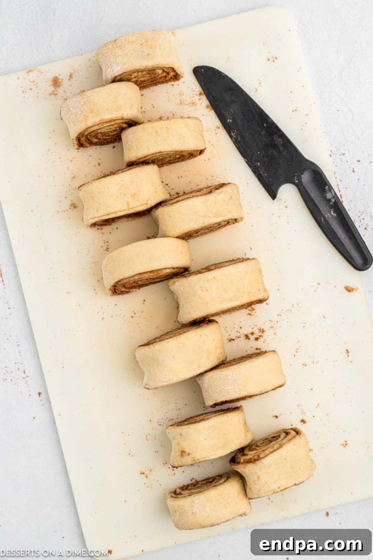 Crafting Perfect Cinnabon Cinnamon Rolls 9 Rolled cinnamon roll dough carefully cut into individual slices, ready for baking.