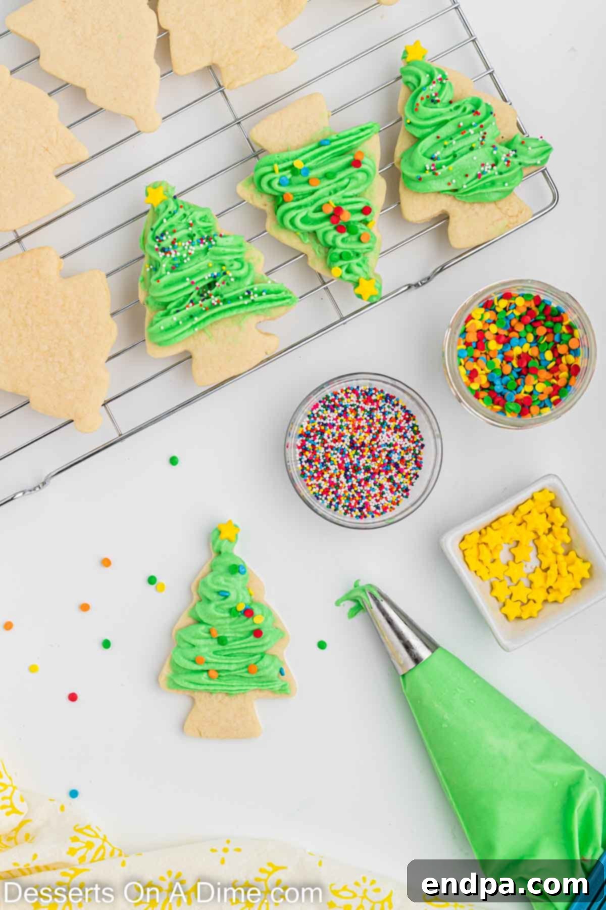 Holiday Tree Sugar Cookie Delights 11 Christmas tree sugar cookies being decorated with green frosting piped on in a festive pattern, then topped with colorful sprinkles.