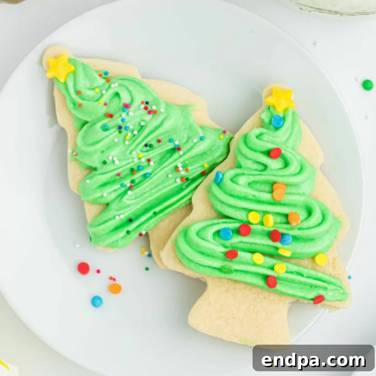 Holiday Tree Sugar Cookie Delights 13 Christmas tree sugar cookies with frosting on a white plate, showcasing their inviting appeal.