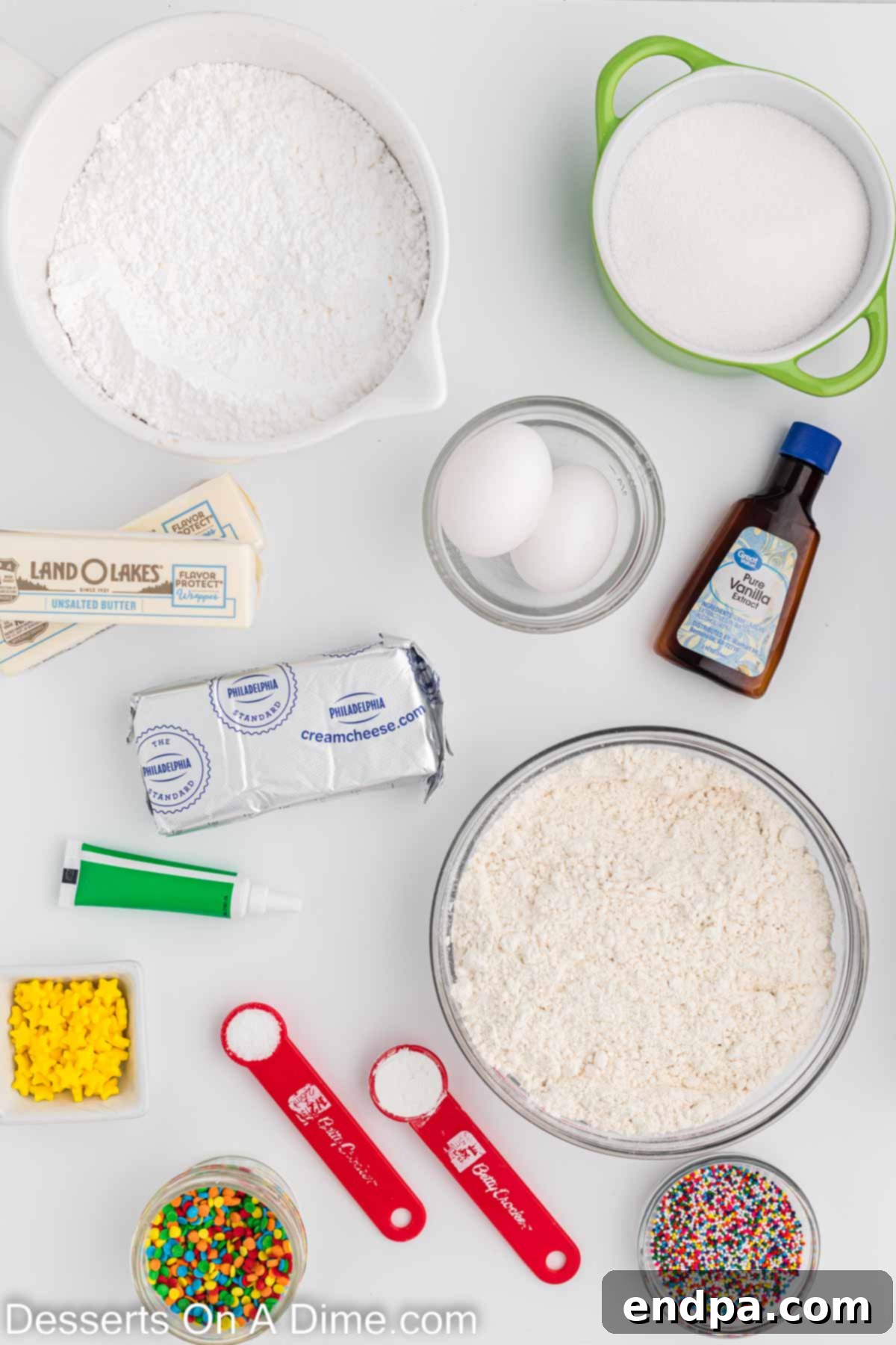 Holiday Tree Sugar Cookie Delights 3 A visual display of all the key ingredients for making Christmas Tree Sugar Cookies, including flour, eggs, vanilla, cream cheese, butter, baking powder, and sprinkles, laid out on a clean surface.