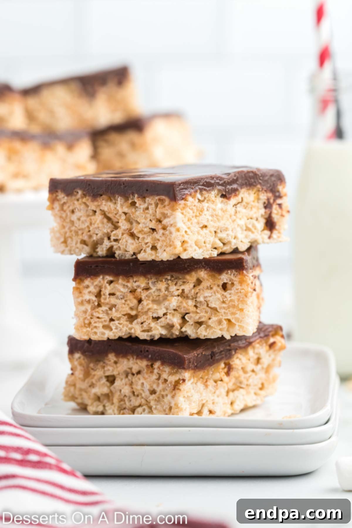 Stacked Chocolate Caramel Rice Krispie Treats showcasing layers of crispy cereal, rich caramel, and smooth chocolate.