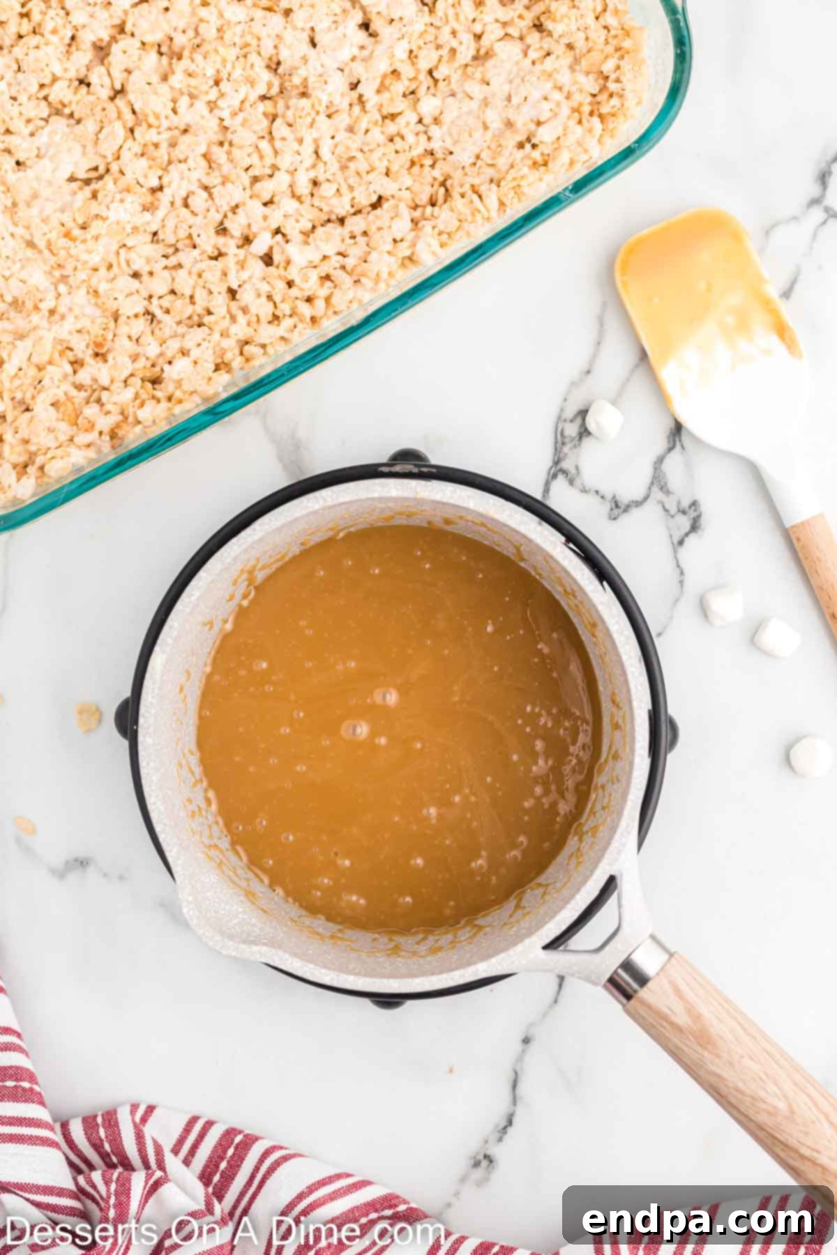 Caramel mixture simmering and thickening in a saucepan.