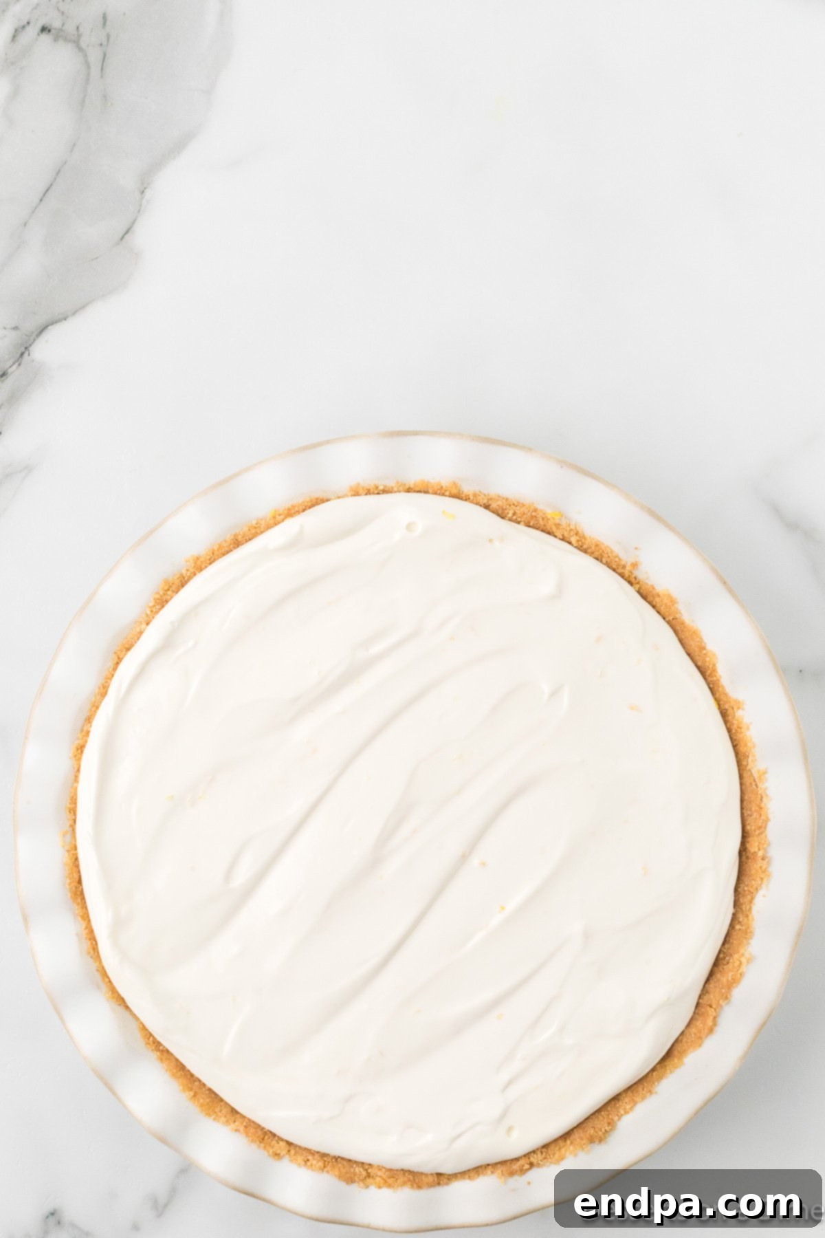 Cool Lemon Cloud Pie 9 The lemonade pie filling being poured into the prepared graham cracker crust.