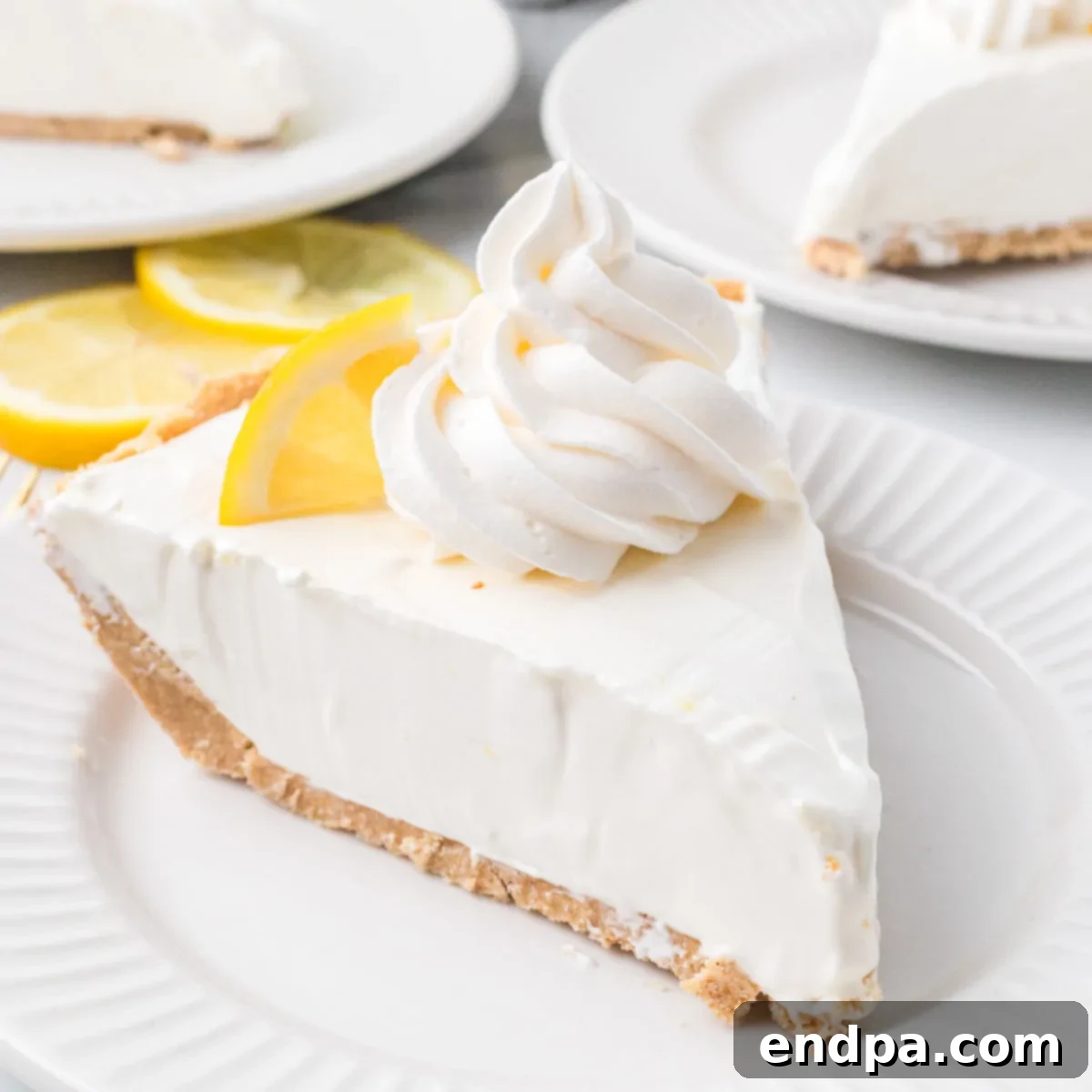 Cool Lemon Cloud Pie 10 A whole Lemonade Pie, garnished with lemon slices and berries, ready to be served.