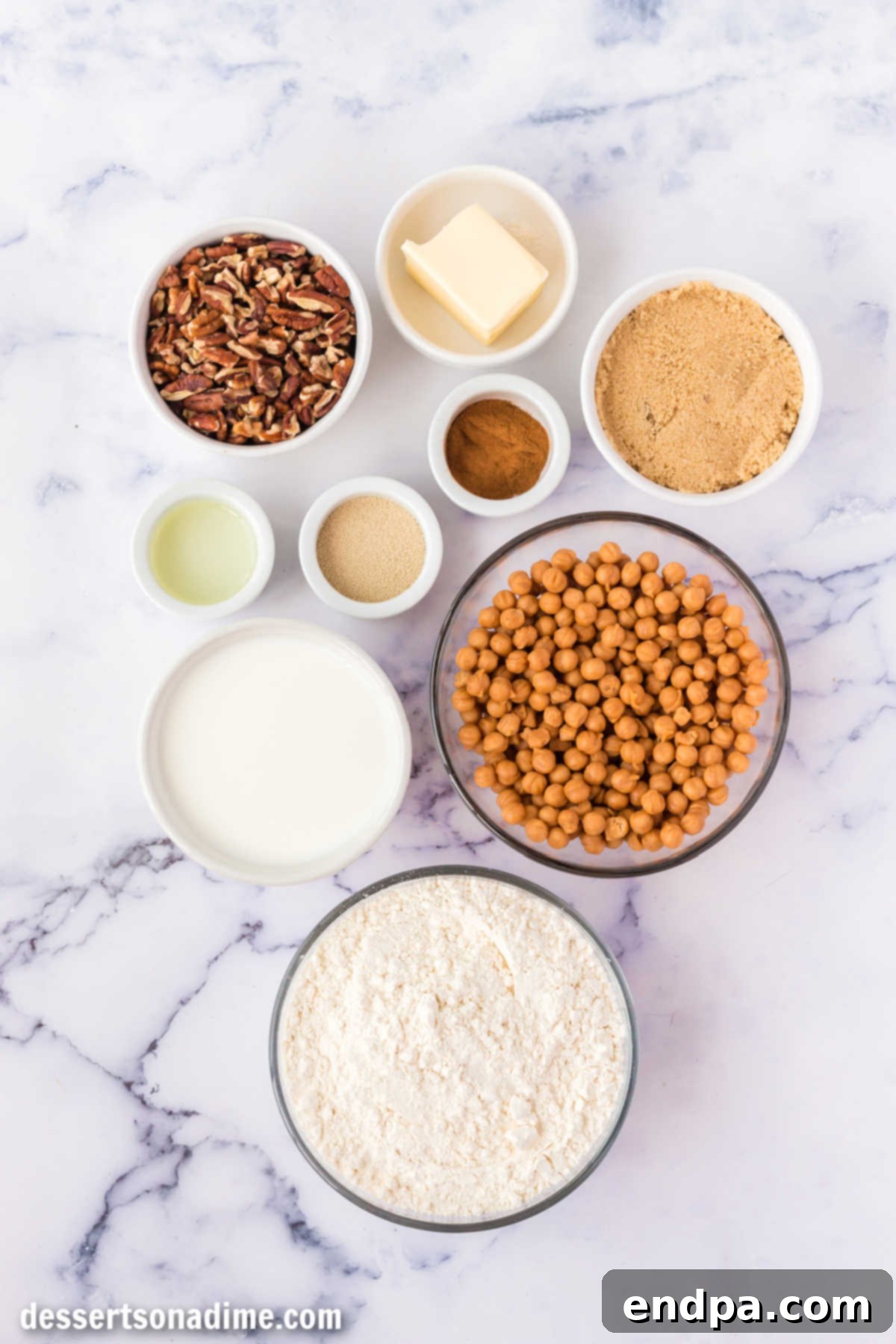 Ingredients for Caramel Pecan Cinnamon Rolls laid out: milk, active dry yeast, all-purpose flour, salted butter, light brown sugar, ground cinnamon, butterscotch chips, and chopped pecans.