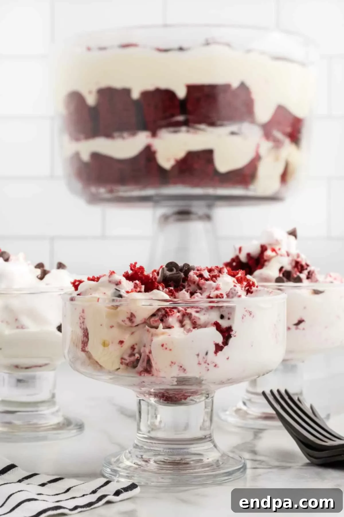 Crimson Velvet Dream 2 Red velvet trifle in a serving bowl. A beautiful, layered dessert with red cake and white cream.