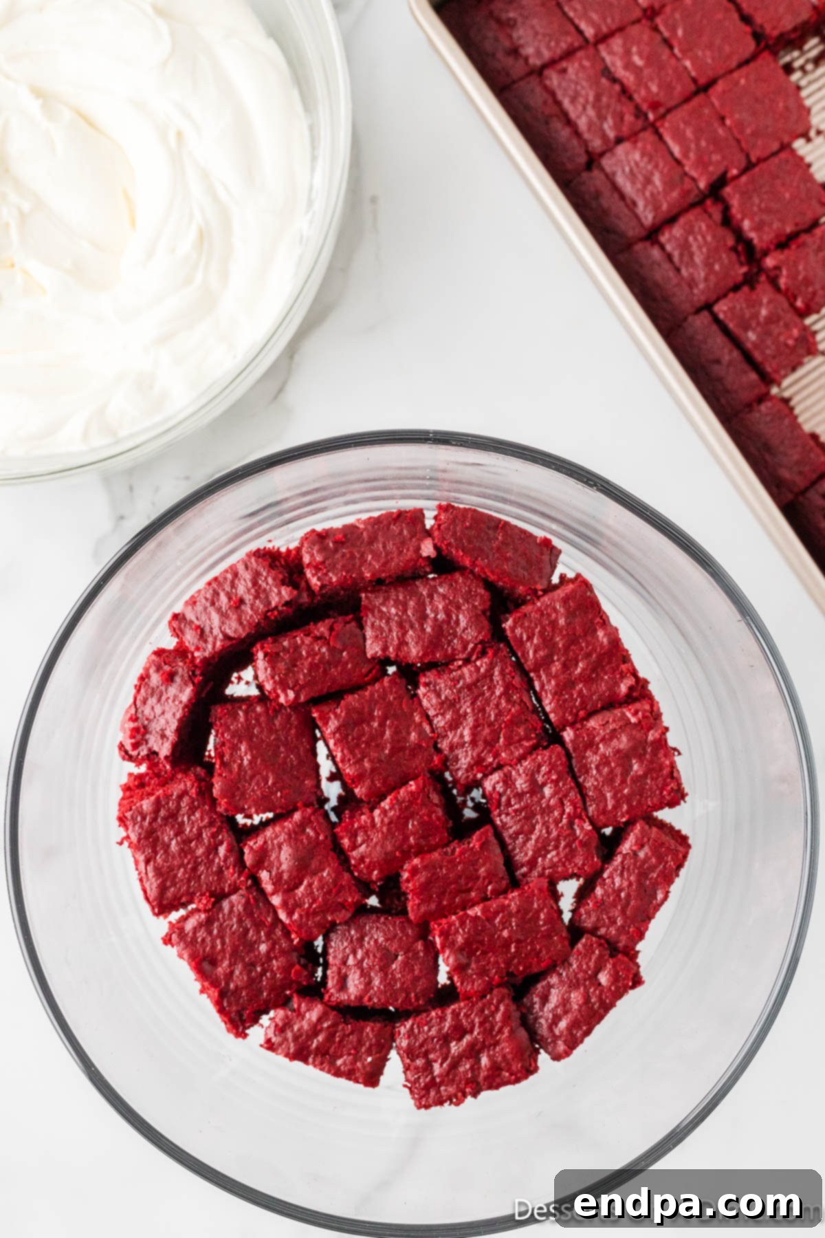 Crimson Velvet Dream 12 Cake cubes layered in dish. The first layer of red velvet cake cubes in a trifle dish.