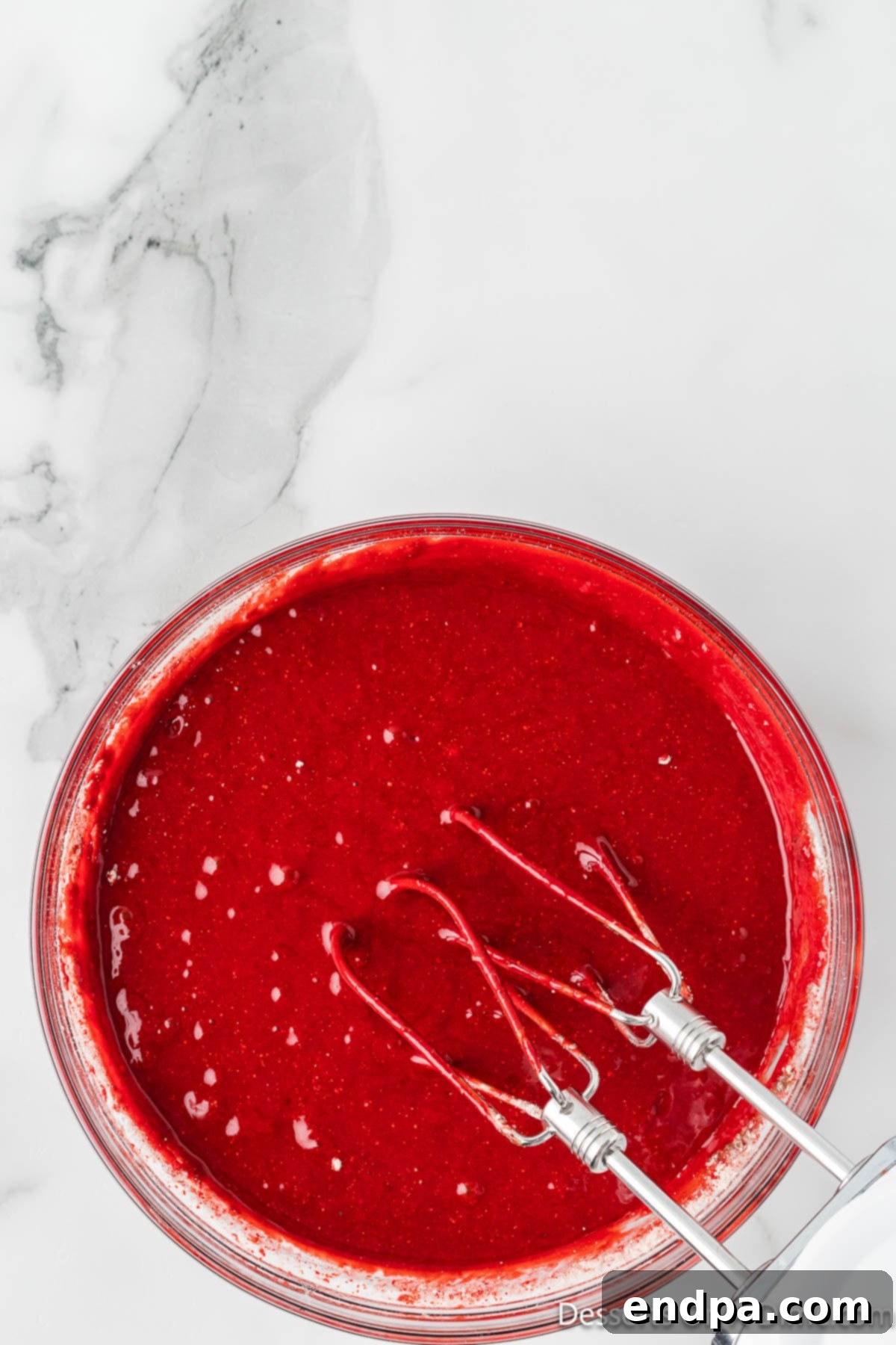 Crimson Velvet Dream 4 Cake batter combined in bowl. A vibrant red batter, ready for baking.
