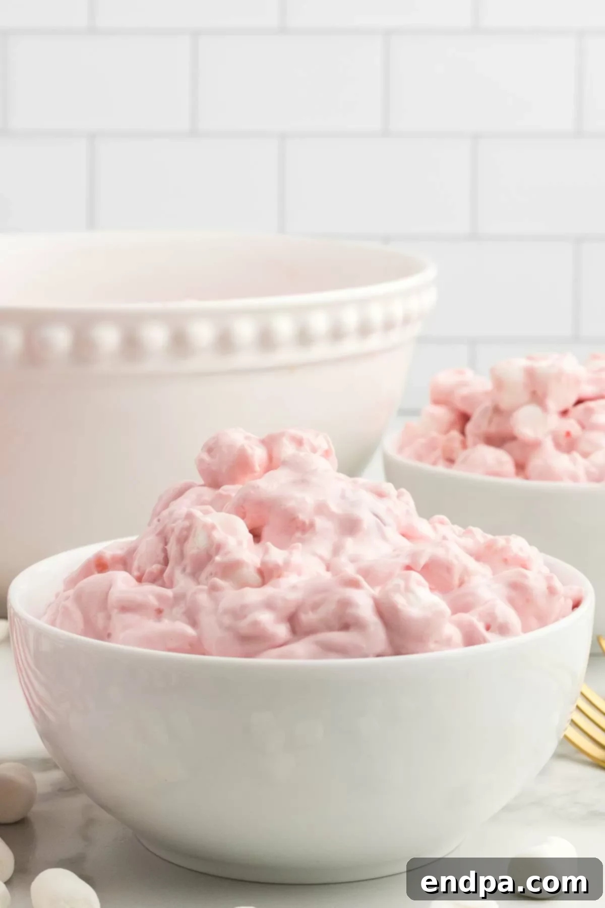 A wide shot of the beautiful Cherry Fluff recipe, showcased in a clear serving bowl.