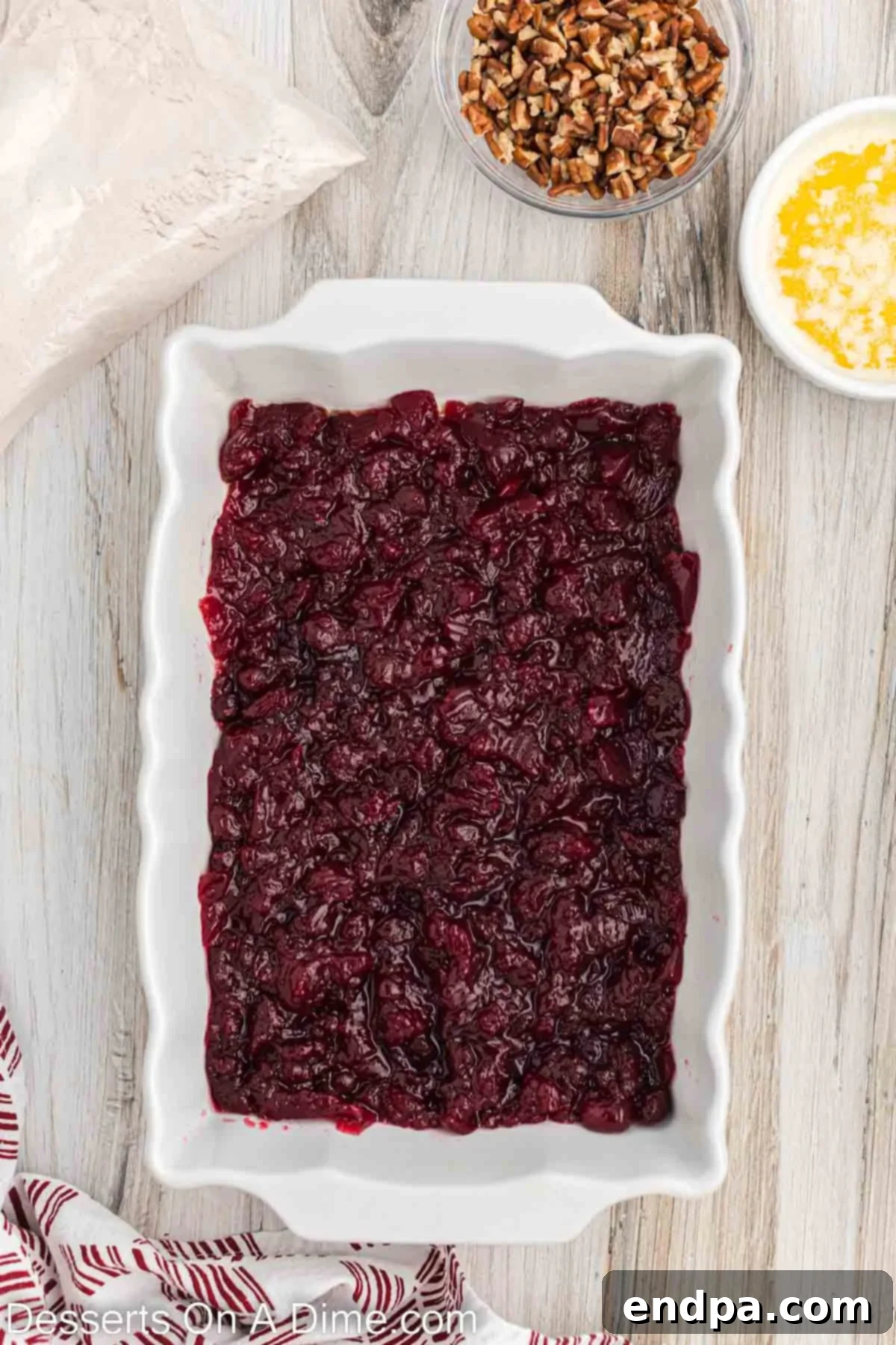 Cranberry sauce spread evenly in a prepared baking dish.