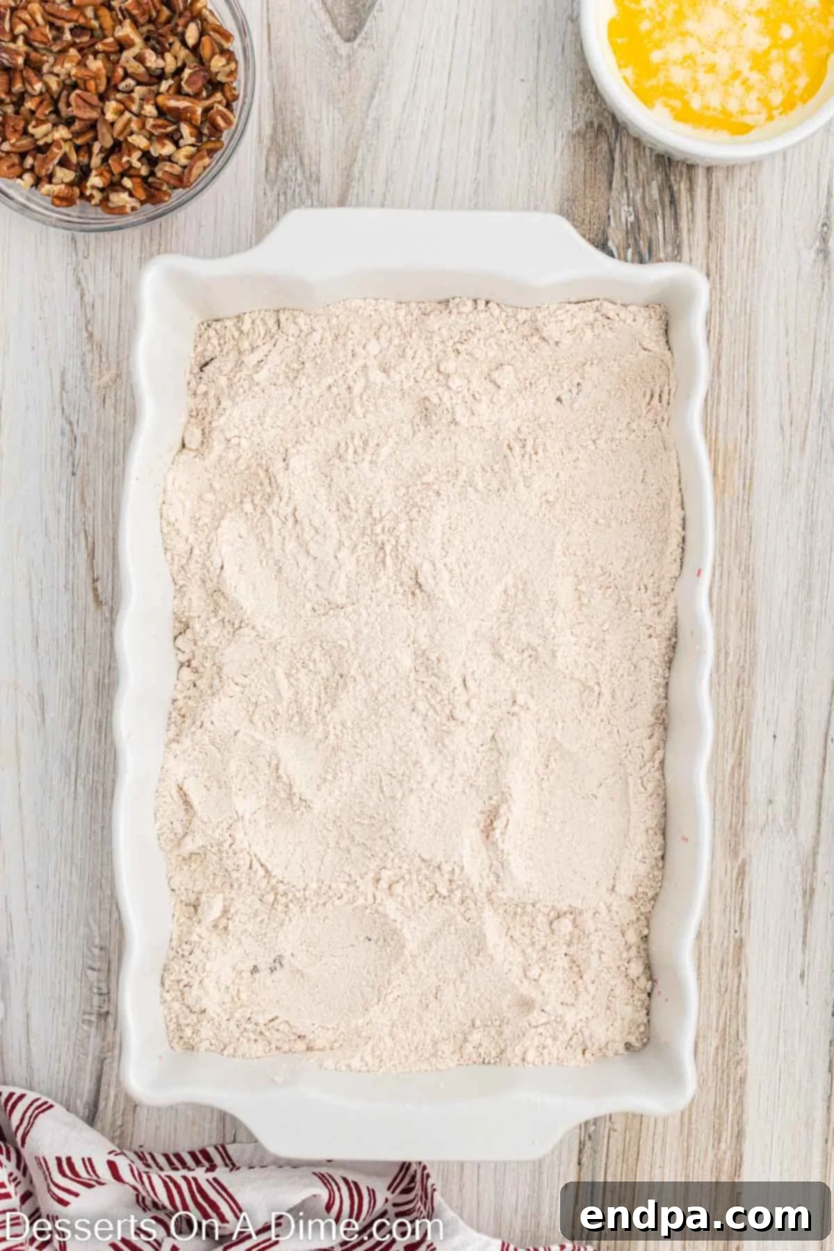 Dry spice cake mix sprinkled over the cranberry sauce in a baking pan.