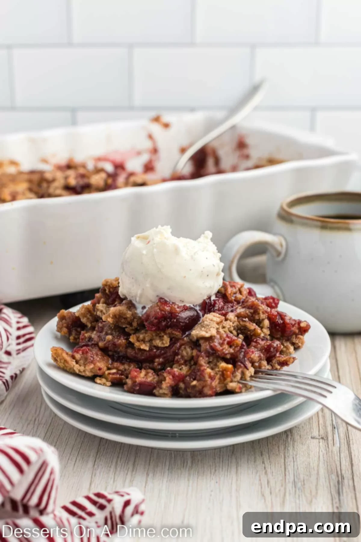 A scoop of Christmas dump cake on a plate, topped with a generous dollop of vanilla ice cream.