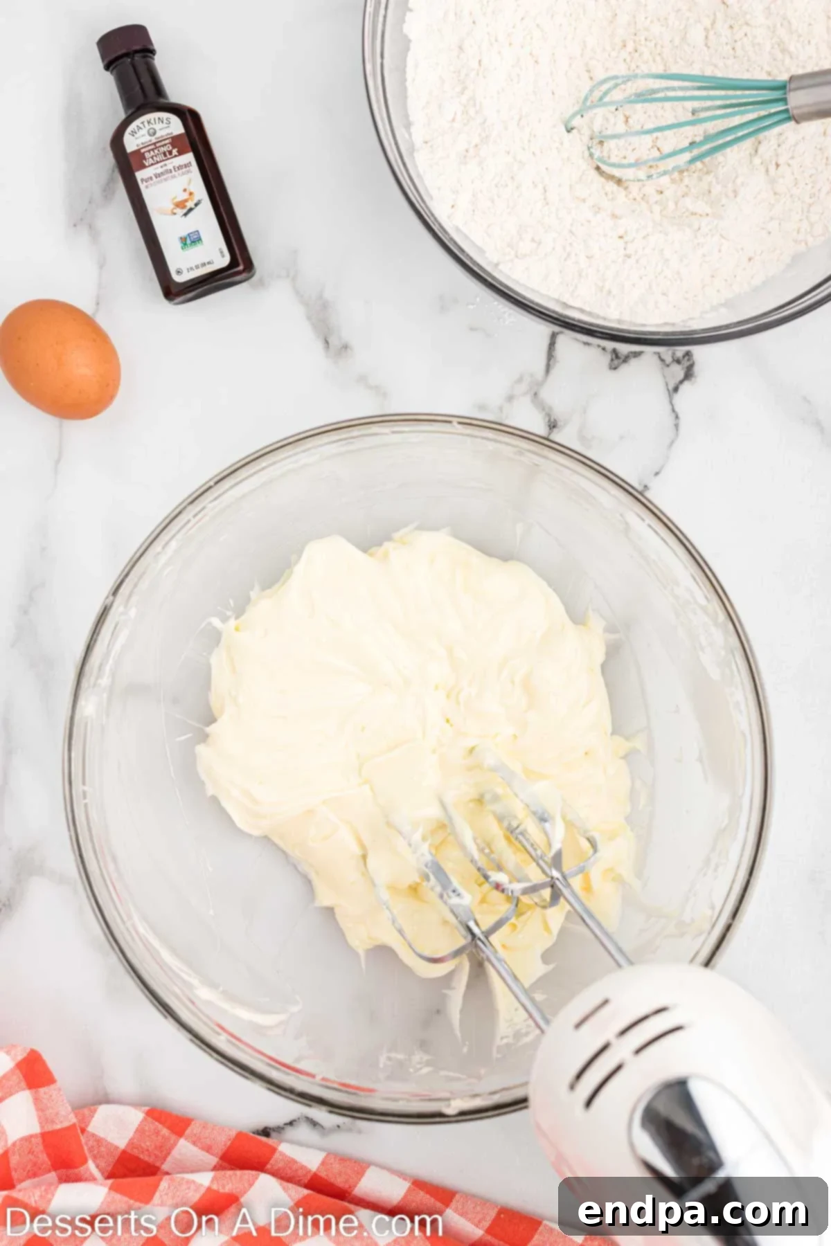 Creamed mixture of melted white chocolate, softened butter, and powdered sugar in a bowl.