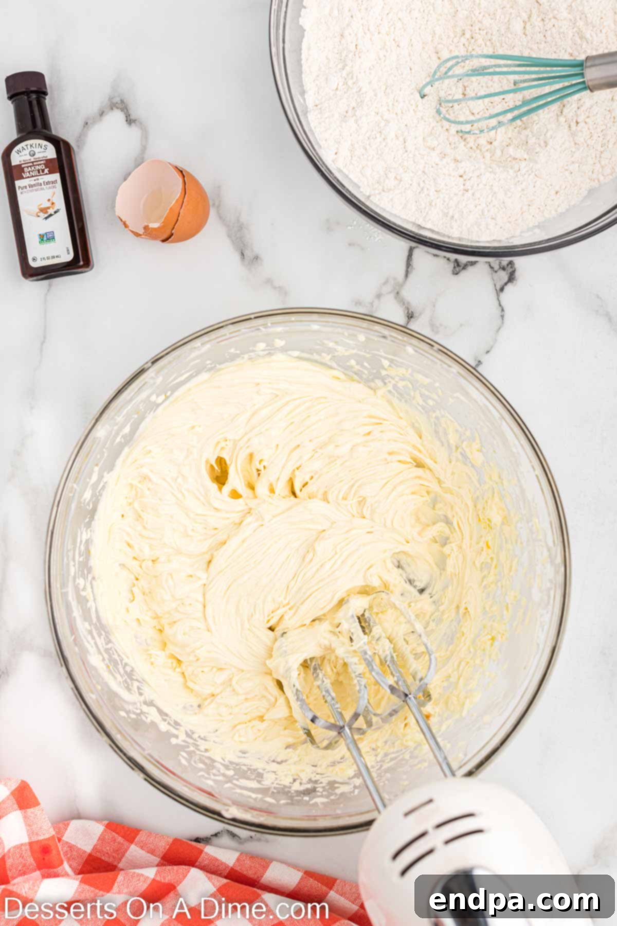 Eggs and vanilla extract being mixed into the creamed butter and chocolate mixture.