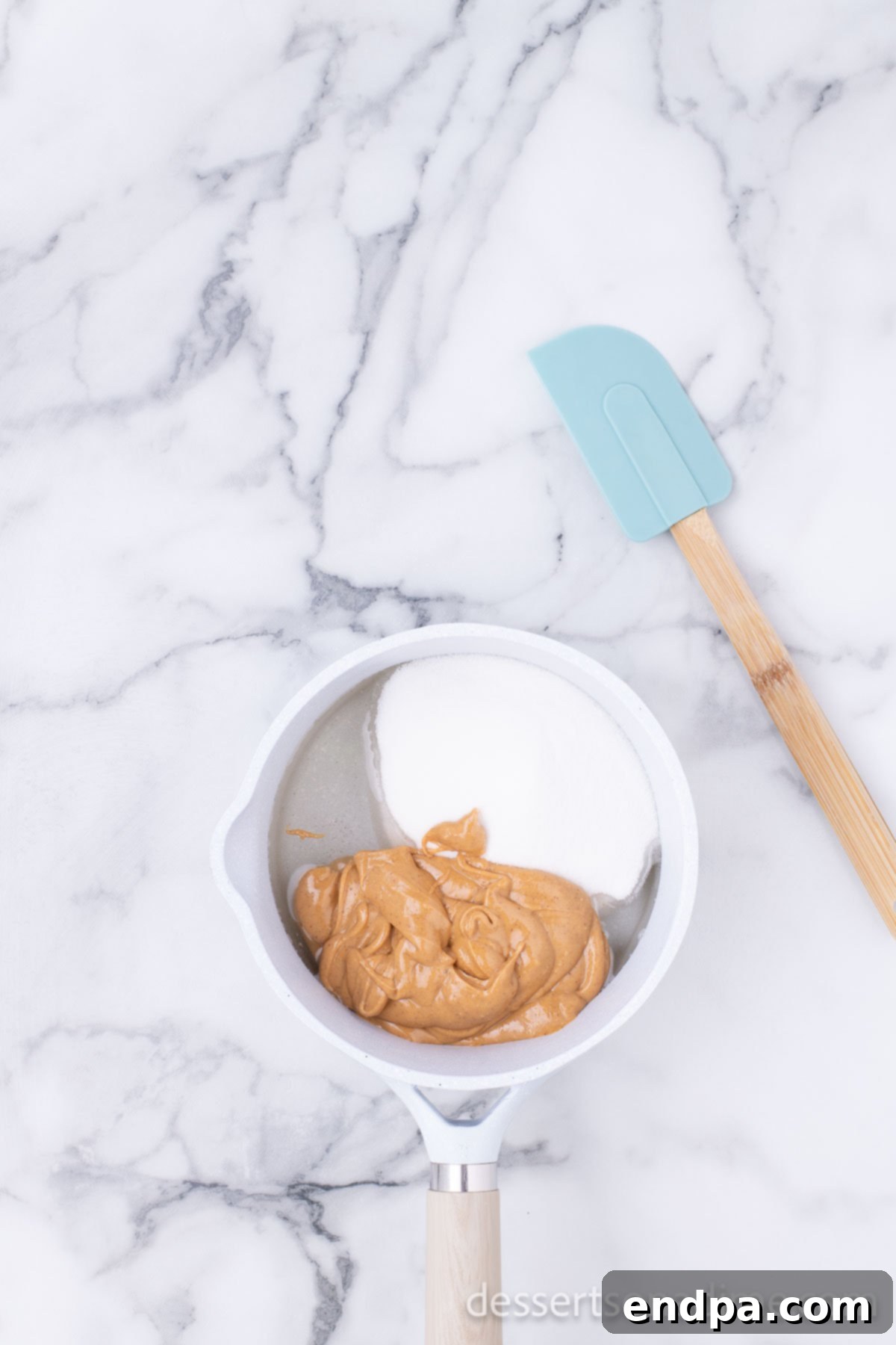 Cornflake Crunch Cookies 5 Creamy peanut butter being stirred into the simmering sugar and corn syrup mixture in a saucepan.