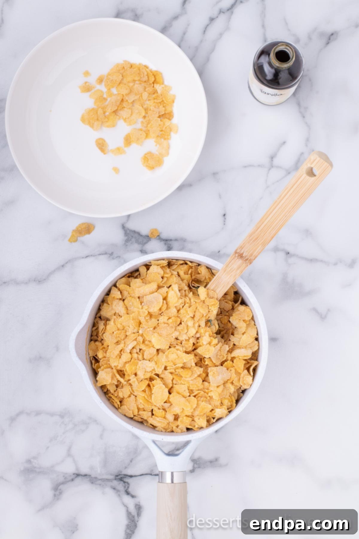 Cornflake Crunch Cookies 6 Cornflake cereal being gently folded into the warm peanut butter mixture in a large saucepan.