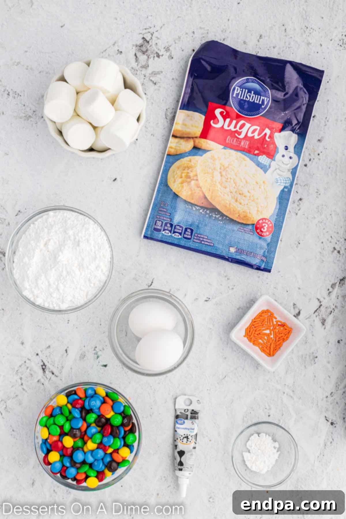 Whimsical Melted Snowman Treats 3 Ingredients for melted snowman cookies - sugar cookie mix, marshmallows, sprinkles, M&Ms, black decorating gel. A flat lay shows all the necessary components neatly arranged for baking, highlighting the simplicity of the recipe.