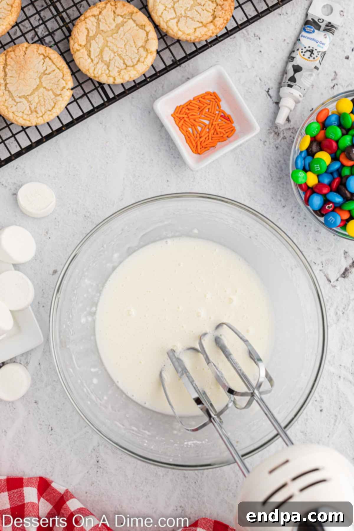 Whimsical Melted Snowman Treats 4 Bowl with icing being combined. A white mixing bowl contains royal icing ingredients, being whipped into a smooth, glossy consistency, ready for cookie decoration.