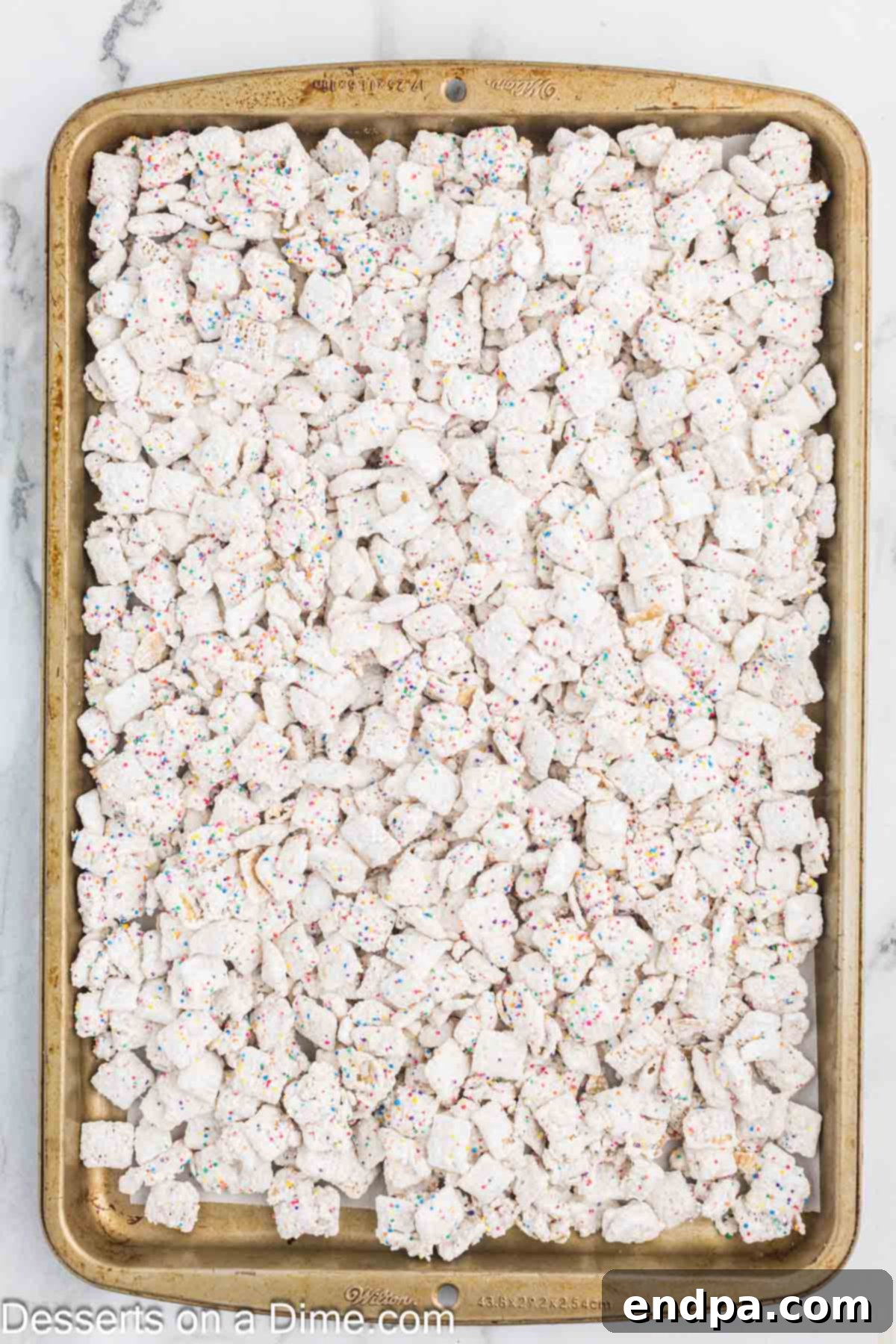 Birthday Cake Snack Mix 7 Coated cereal spread on baking sheet.