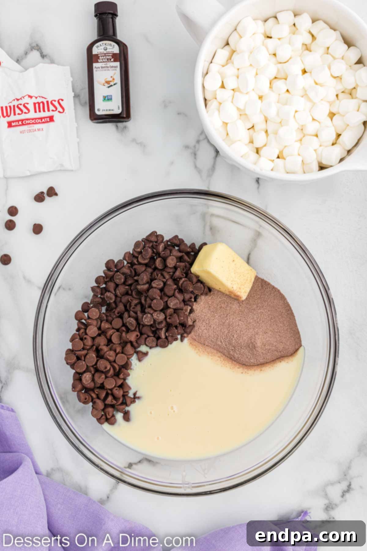 Mixing bowl with semi-sweet chocolate chips, milk chocolate chips, butter, sweetened condensed milk, and hot cocoa mix.
