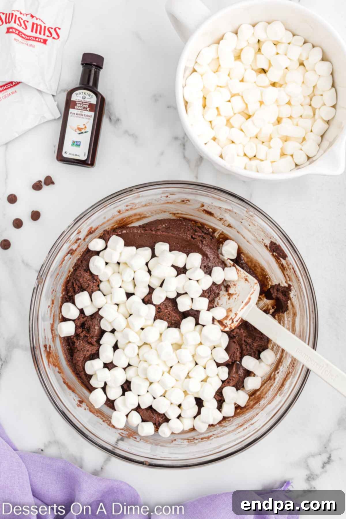 Mini marshmallows added to the melted chocolate mixture in a bowl.