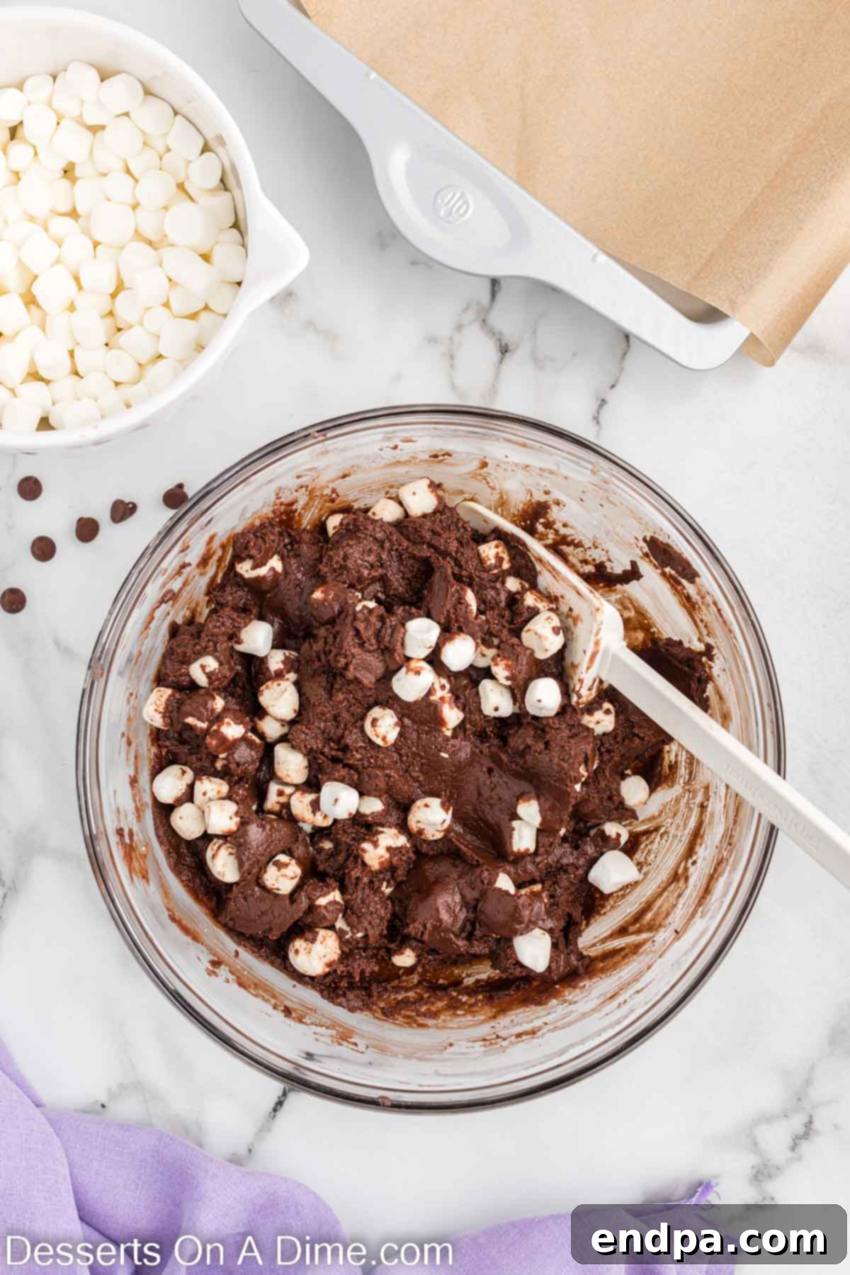 Fudge mixture combined with marshmallows and vanilla, ready to be poured into the pan.