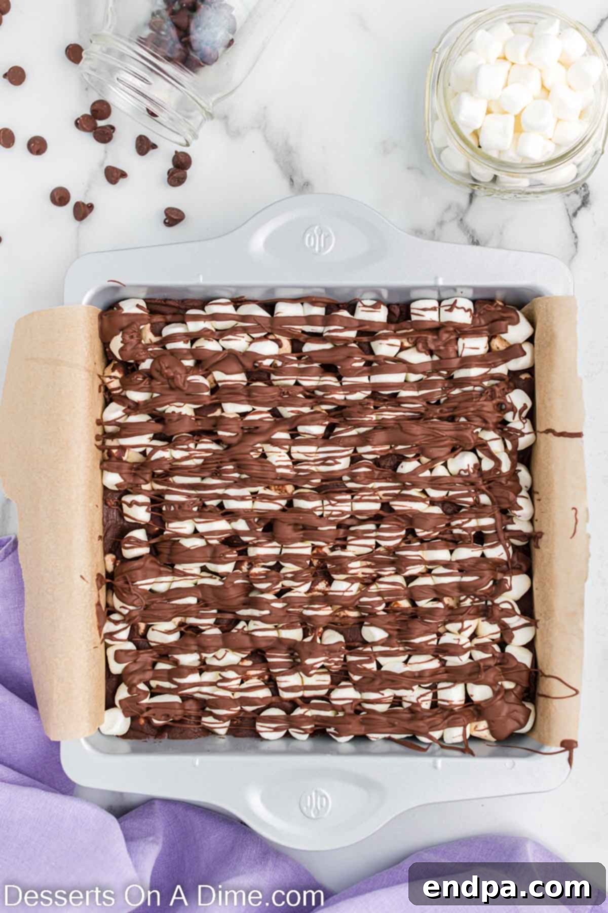 Melted chocolate drizzled artistically over the marshmallow-topped fudge.