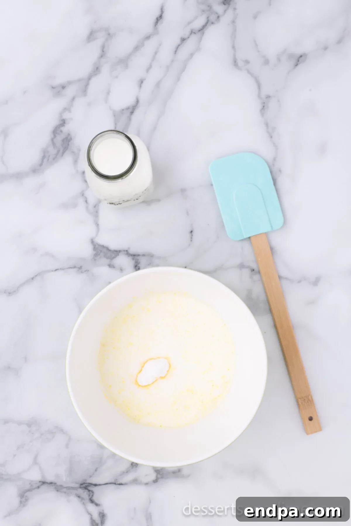 Eclair Cookie Fusion 4 A bowl containing instant vanilla pudding mix and cold milk, freshly combined and ready for whisking until smooth.