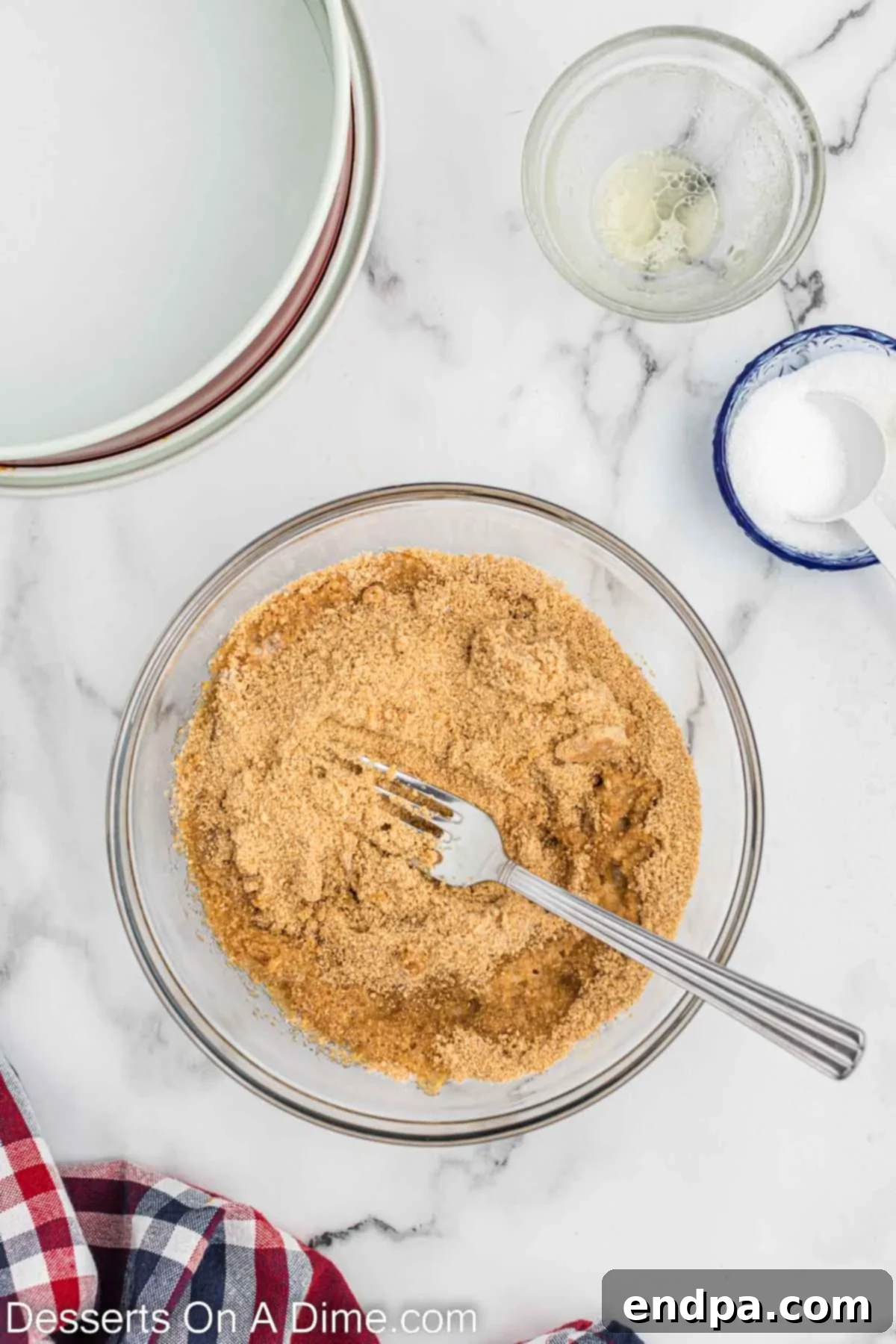 Graham cracker crumbs and butter combined in a bowl. 