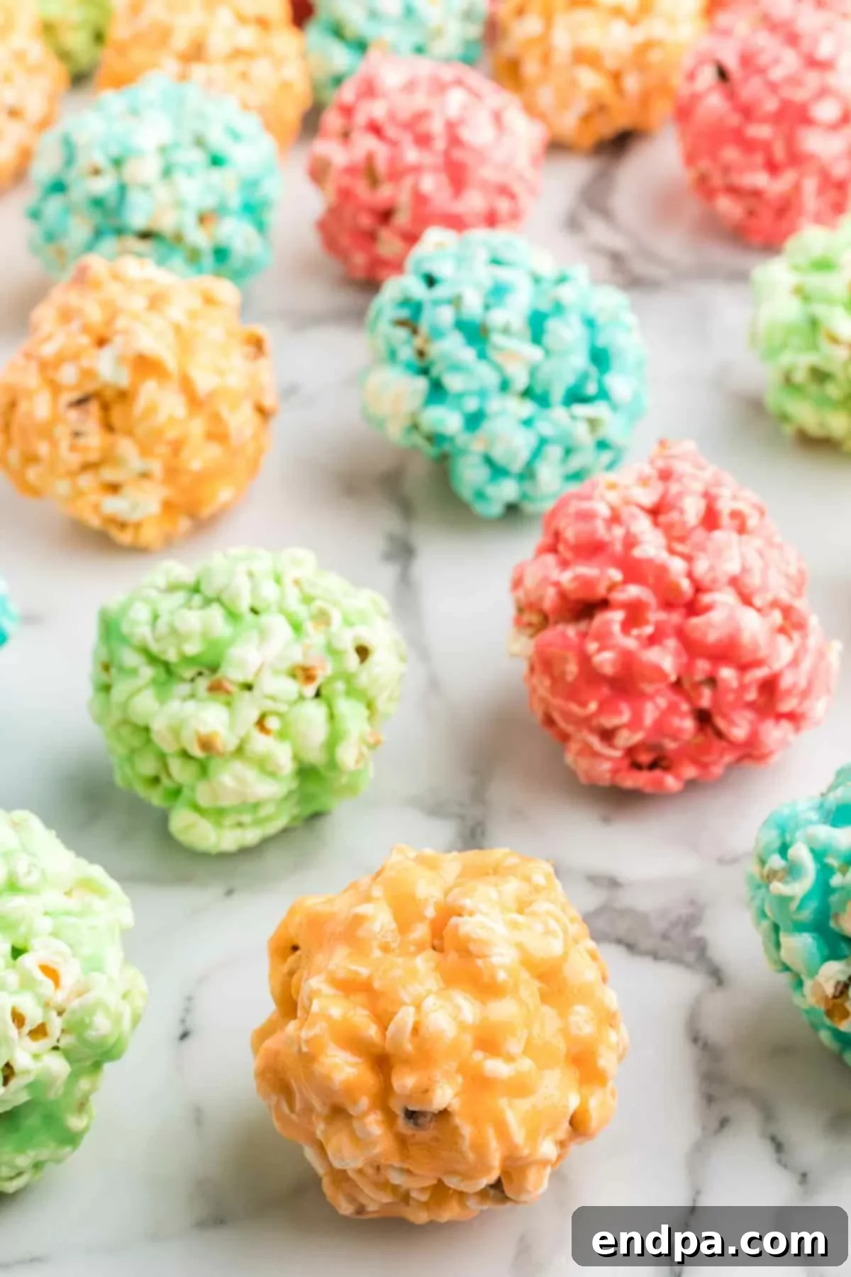 Jello popcorn balls in an assortment of colors, displayed appealingly.