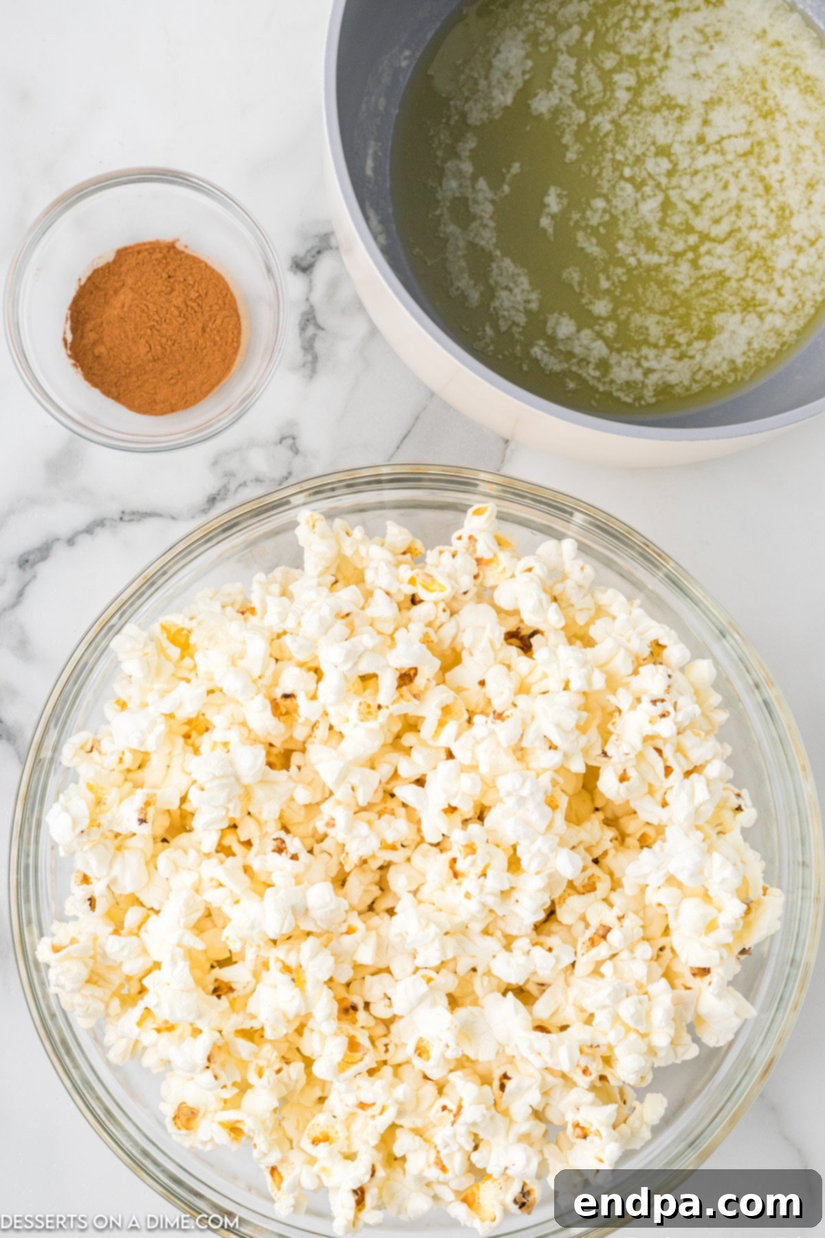 A large bowl filled with freshly popped white popcorn, ready for flavoring.