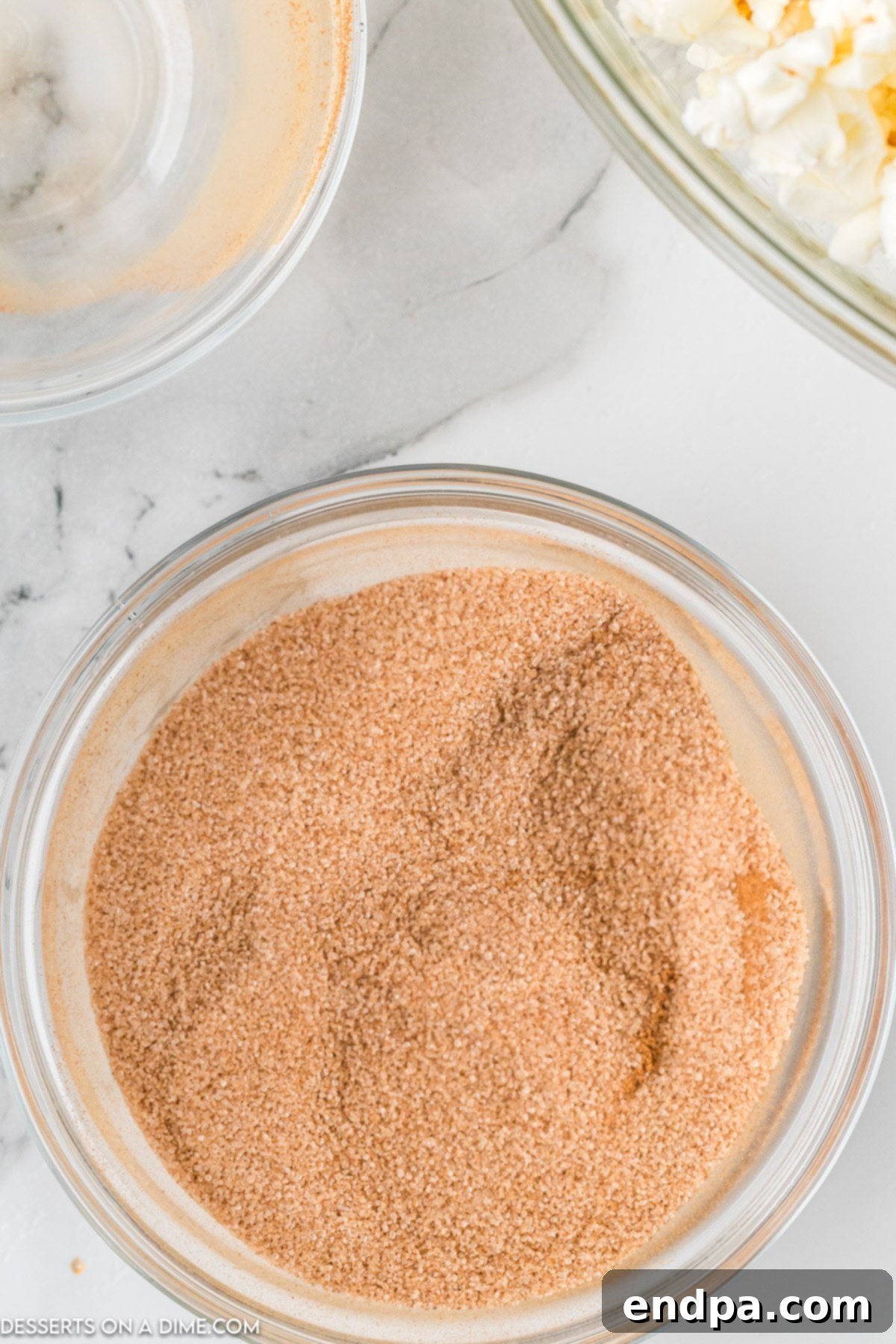 A small bowl containing a mixture of granulated sugar and ground cinnamon, perfectly blended.