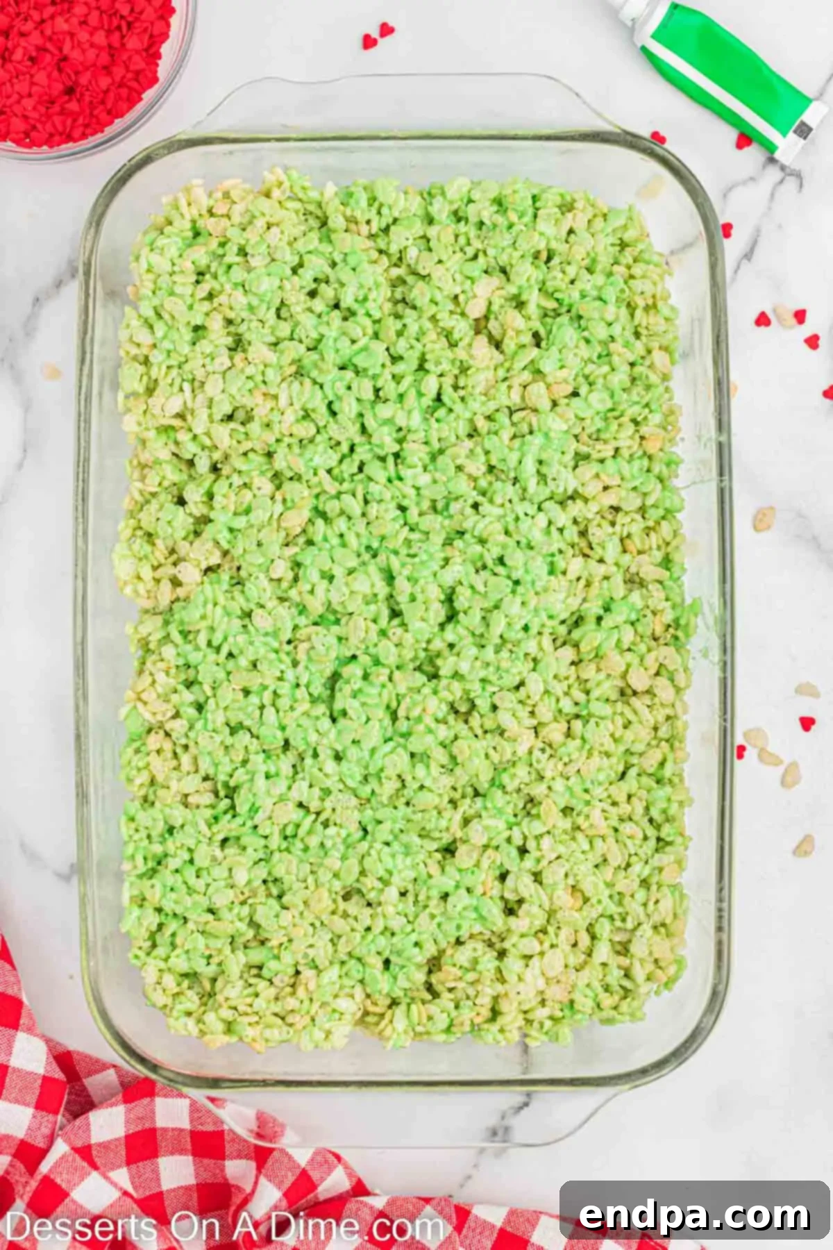 The green Rice Krispie mixture pressed firmly and evenly into a 9x13 inch baking pan.
