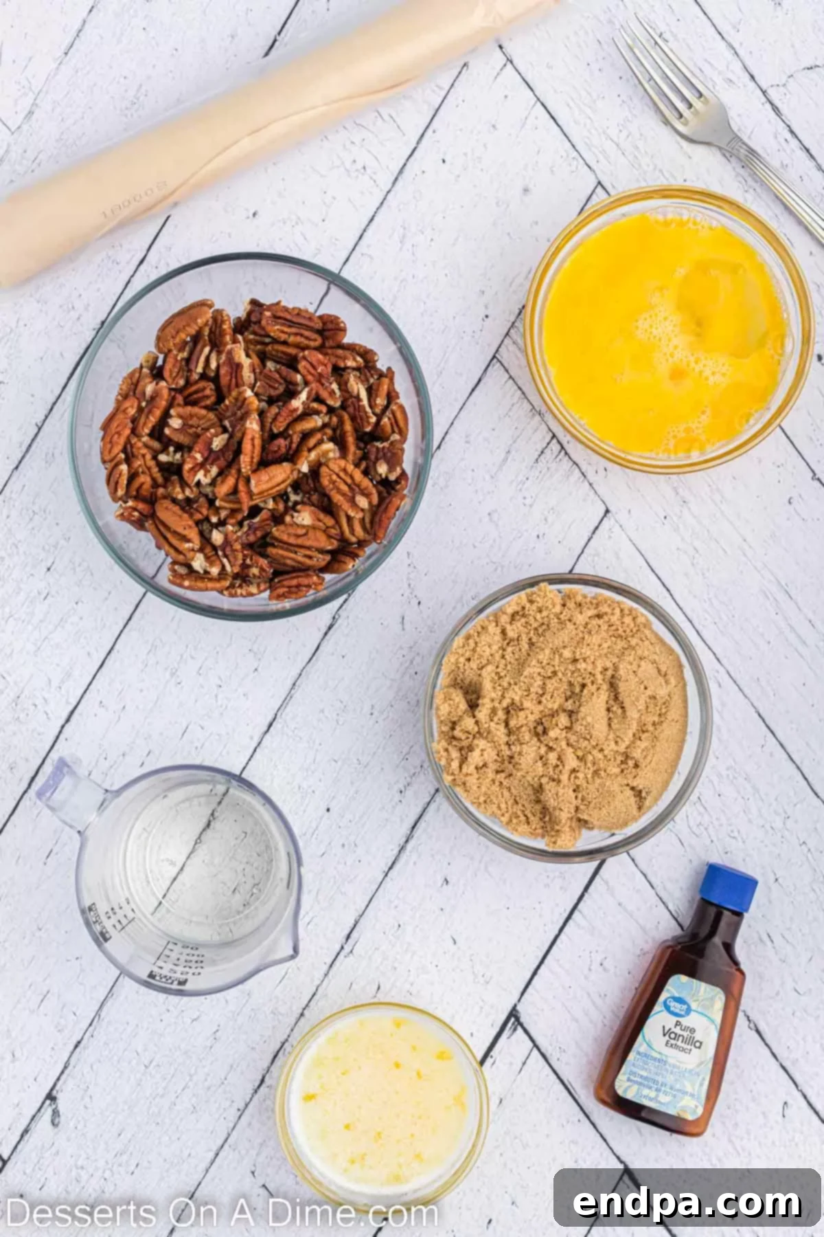 Ingredients for Crock pot pecan pie - pie crust, eggs, corn syrup, brown sugar, butter, vanilla, pecan halves. A beautifully arranged photo of all the necessary ingredients. 