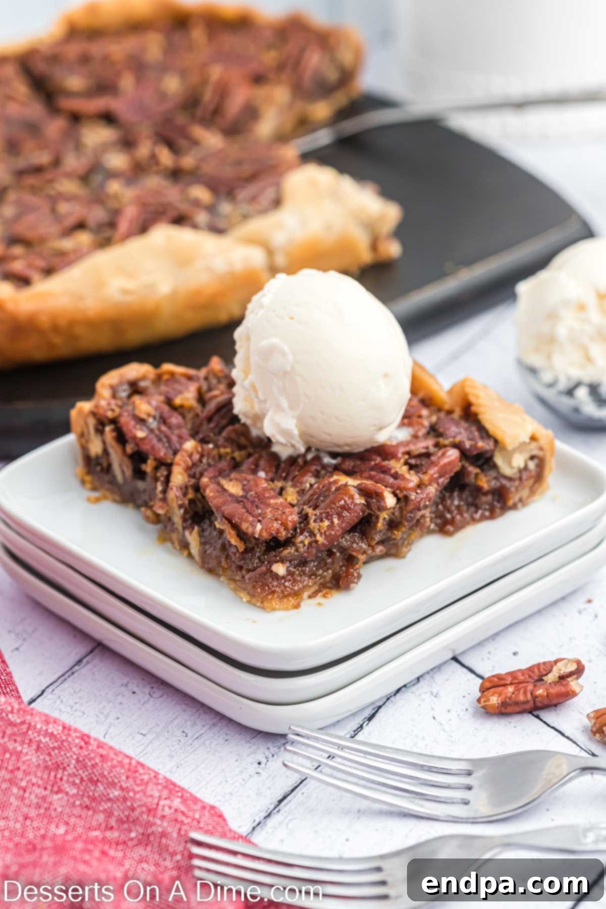 Crock pot pecan pie topped with ice cream. A slice of Crock Pot Pecan Pie, perfectly gooey, served with a scoop of vanilla ice cream.