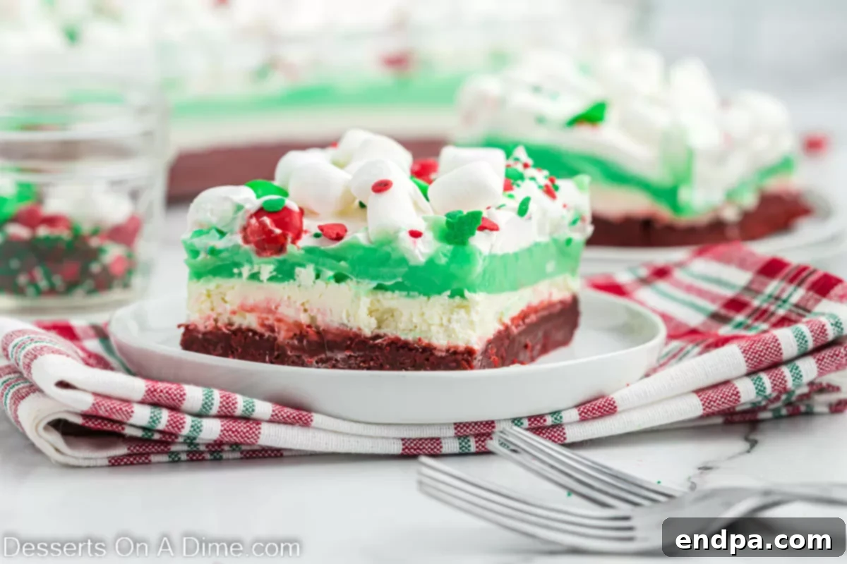 A perfectly sliced piece of Christmas dessert lasagna on a festive plate, showcasing its vibrant layers.
