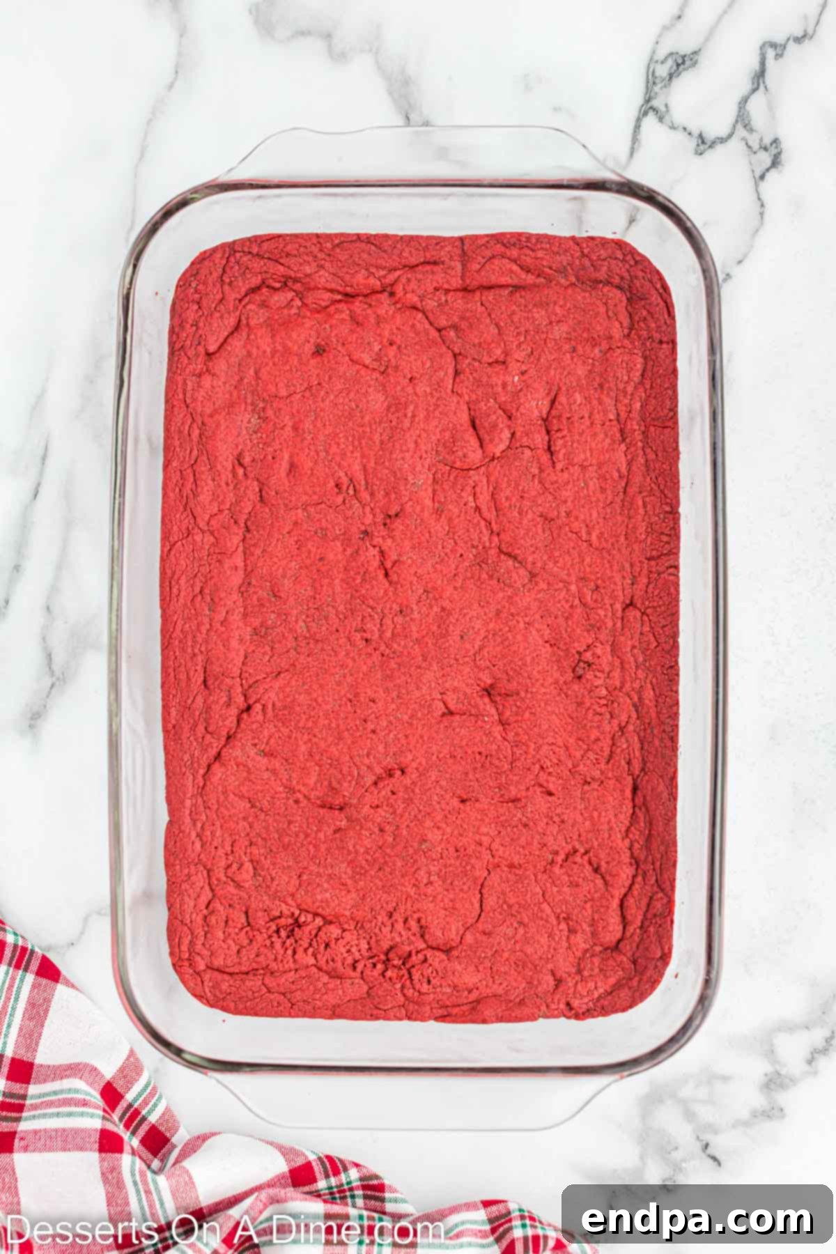 The baked red velvet cake crust cooling in a baking pan.