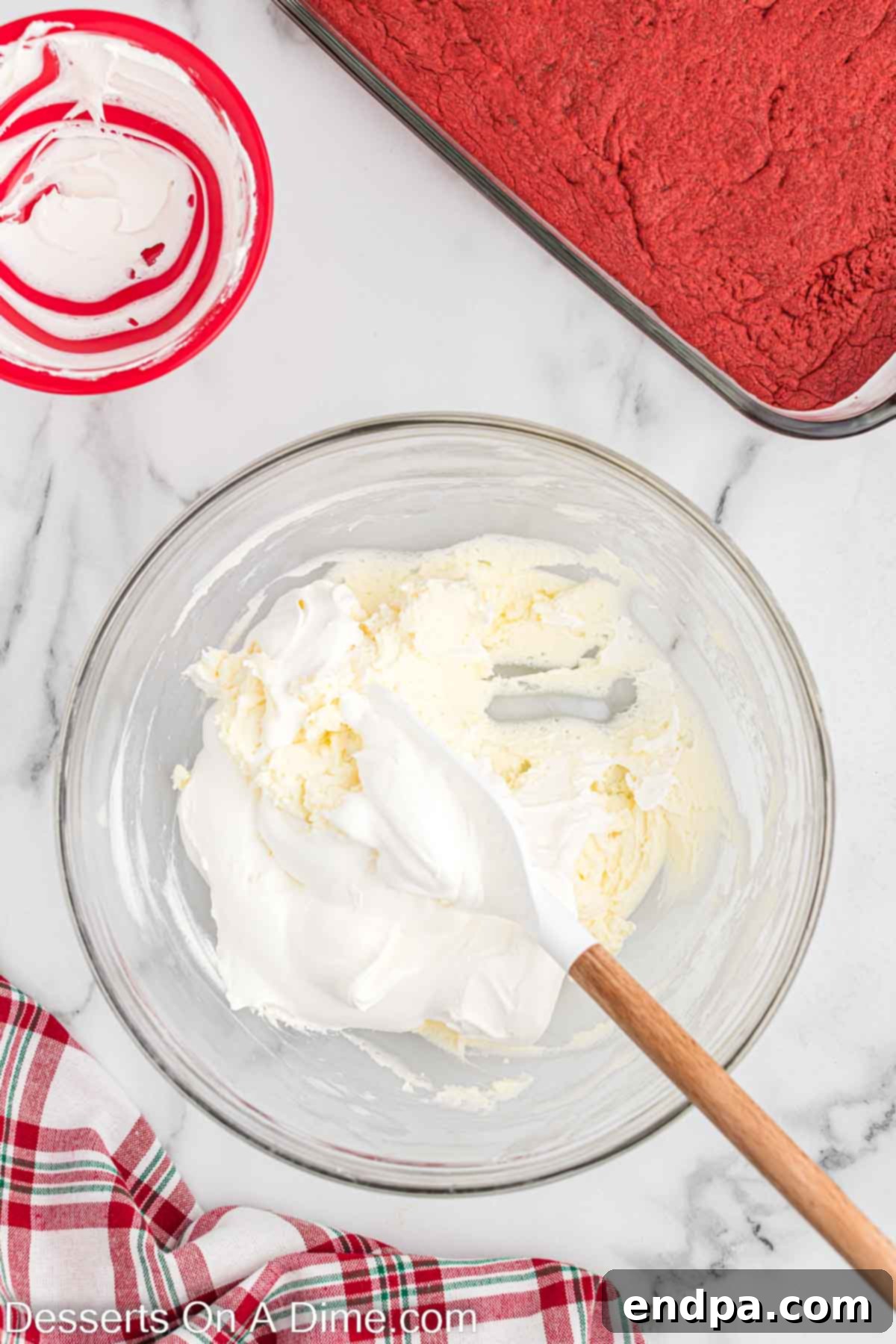 Creamy peppermint cheesecake layer being mixed in a bowl.