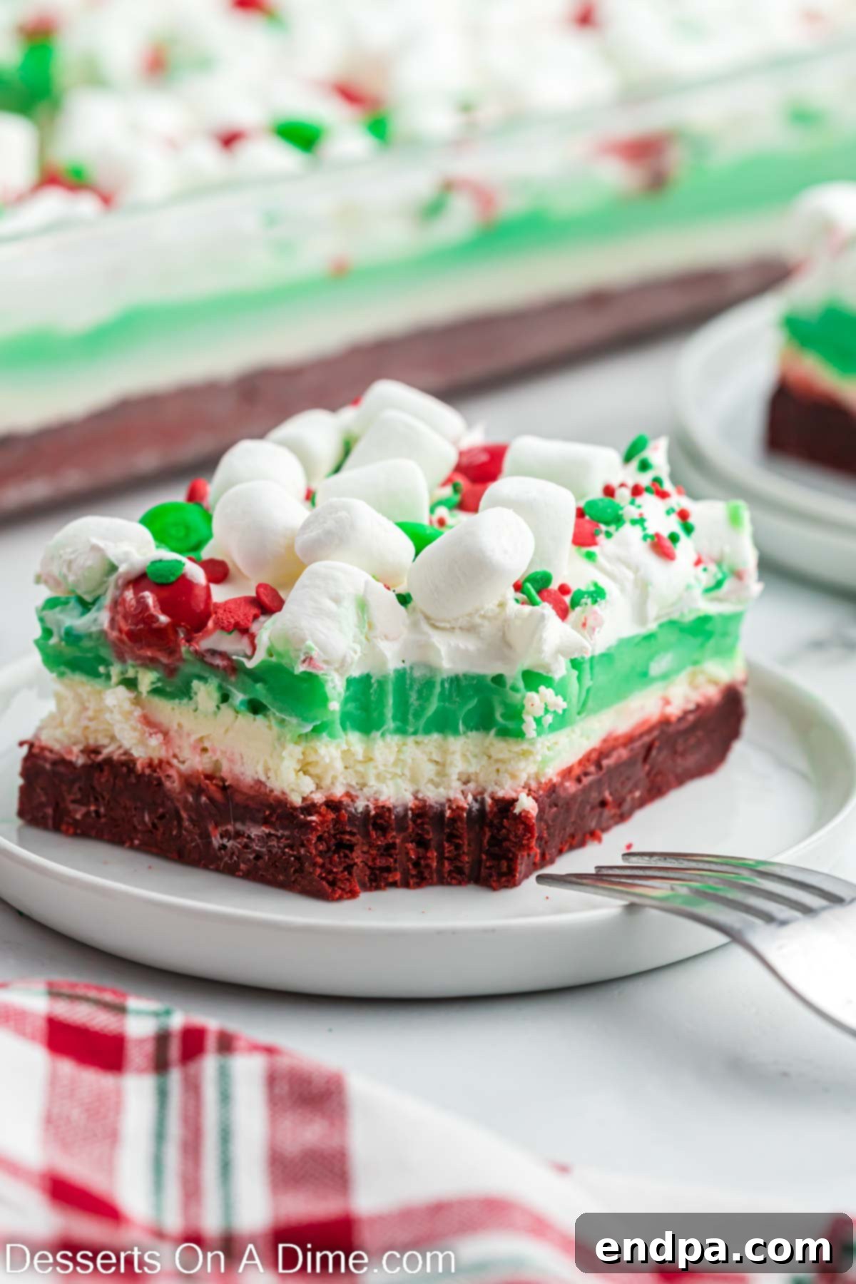 A single slice of Christmas lasagna dessert, perfectly showcasing all its layers, on a festive plate.