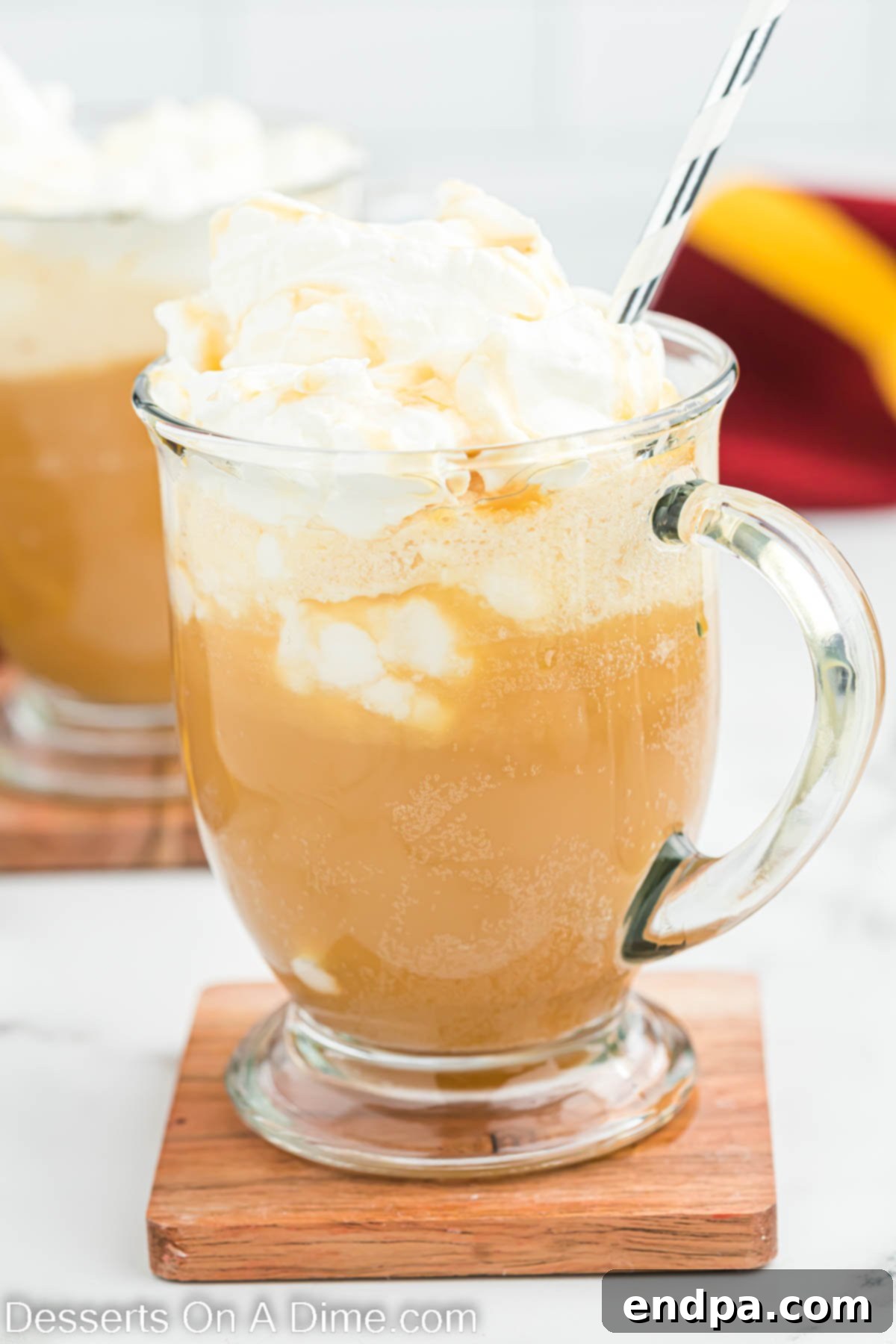 Hogwarts Signature Butterbrew 2 Butter Beer in a mug and topped with whipped topping, ready to be enjoyed at home