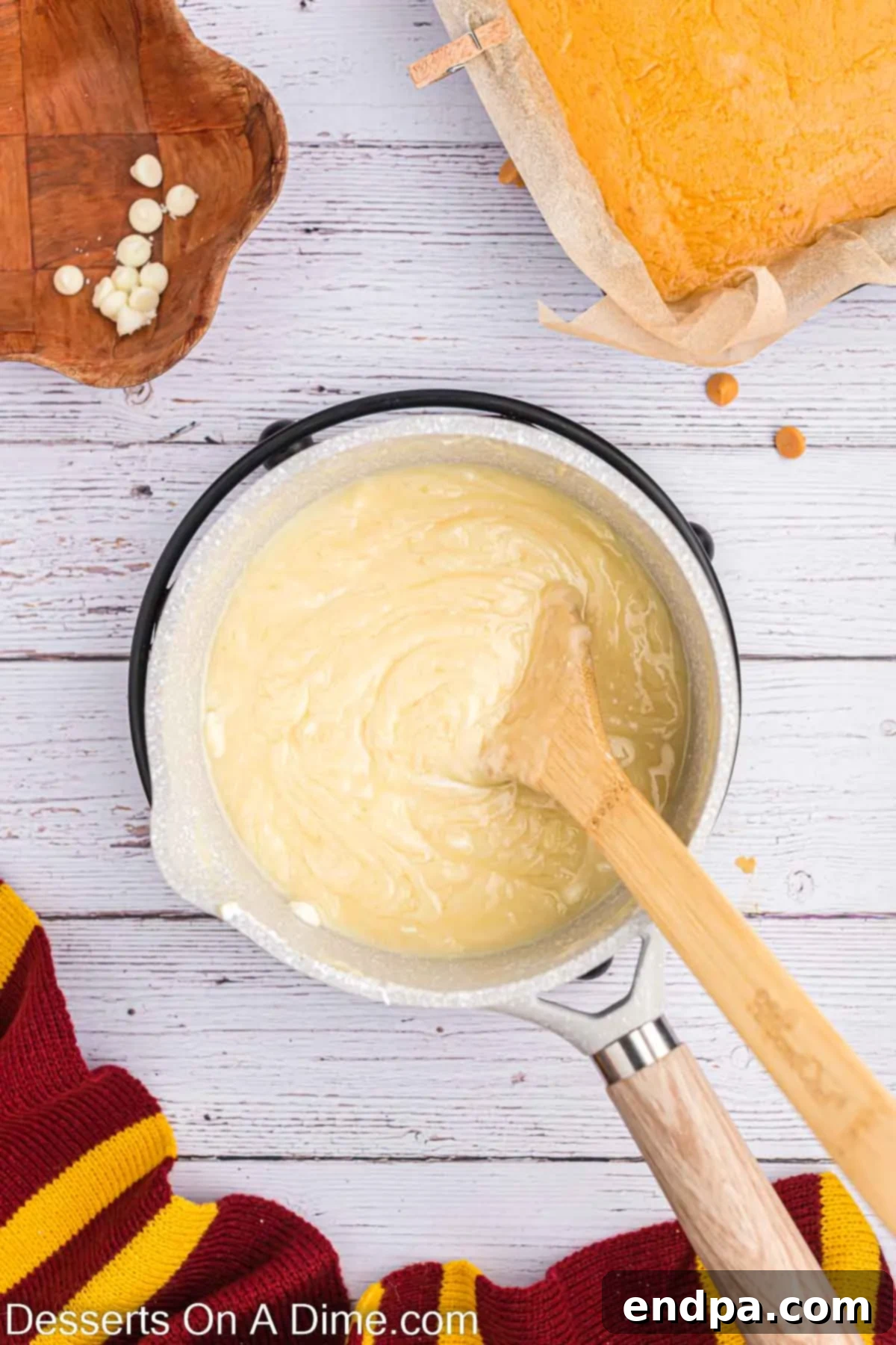 Dreamy Butterbeer Fudge 7 Vanilla fudge mixture coming to a gentle boil in a saucepan, being constantly stirred.