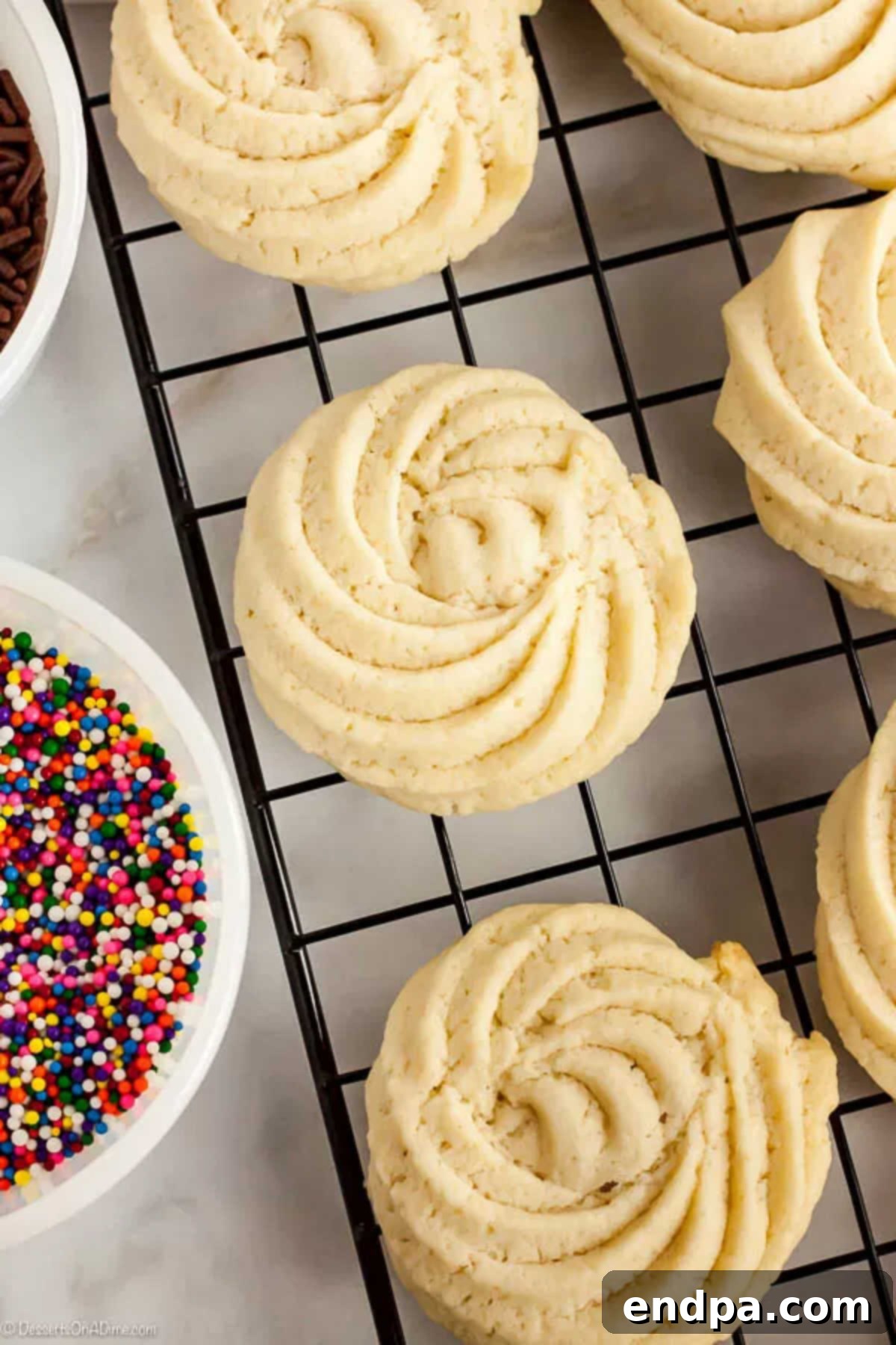 With just a few ingredients, Butter Cookies Recipe comes together quickly for a tasty and gorgeous treat. Easy butter cookies are so pretty and delicious. A cooling rack laden with freshly baked, perfectly golden butter cookies, allowing them to cool down completely before serving or decorating.