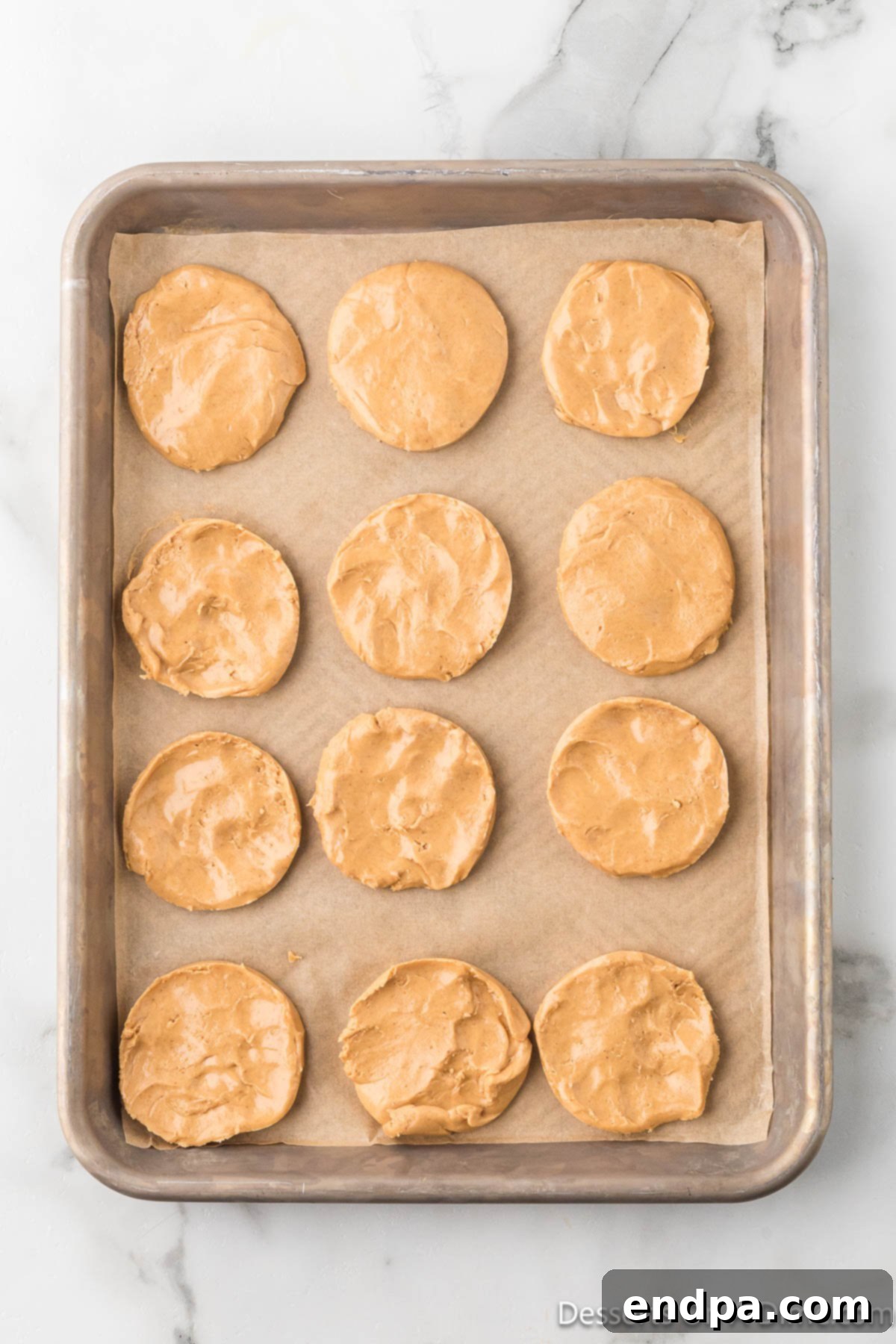 Crumbl Style Buckeye Brownie Cookies 18 Peanut butter balls flattened into discs.