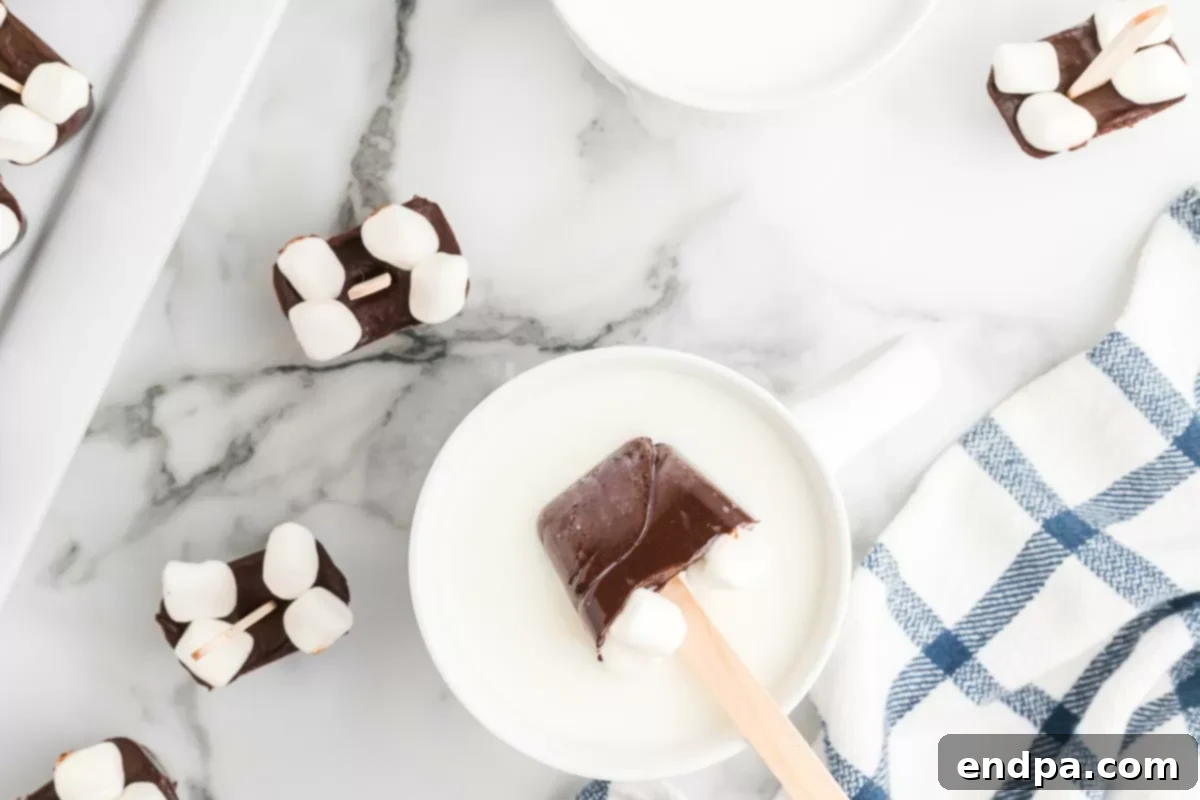 Hot chocolate on a stick dissolving in a mug of warm milk.
