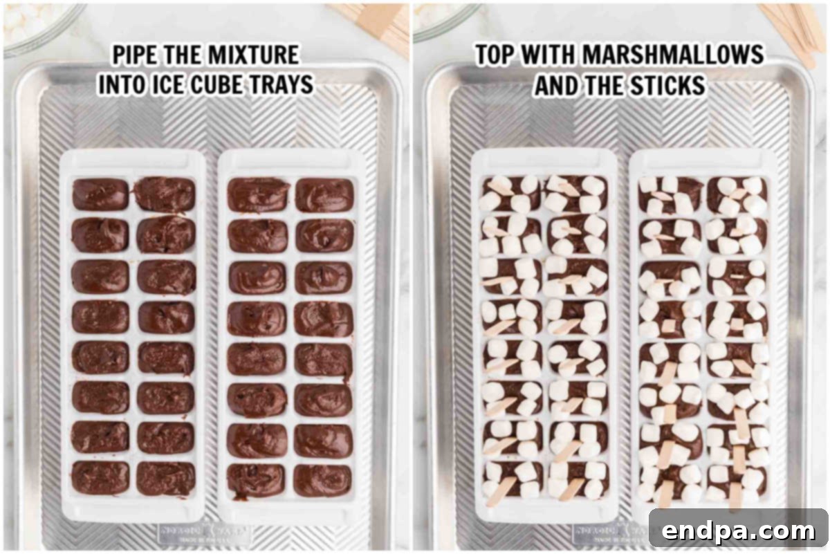 Ice cube trays filled with hot chocolate mixture, topped with mini marshmallows and popsicle sticks.