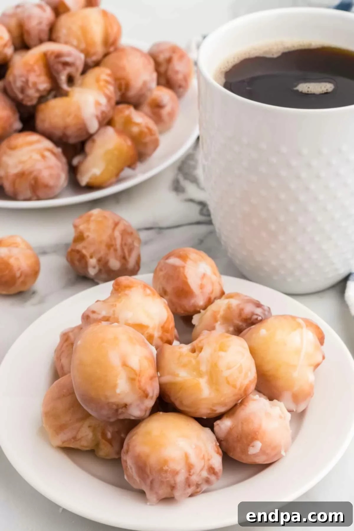 Krispy Kreme Donut Bites 2 A plate piled high with golden-brown, perfectly glazed Krispy Kreme Donut Holes, ready to be enjoyed.