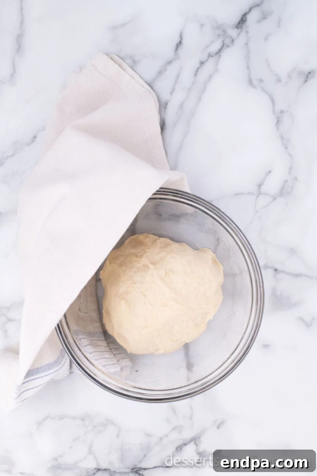 Krispy Kreme Donut Bites 12 Donut dough after rising, now doubled in size within an oiled bowl, indicating successful yeast activation.