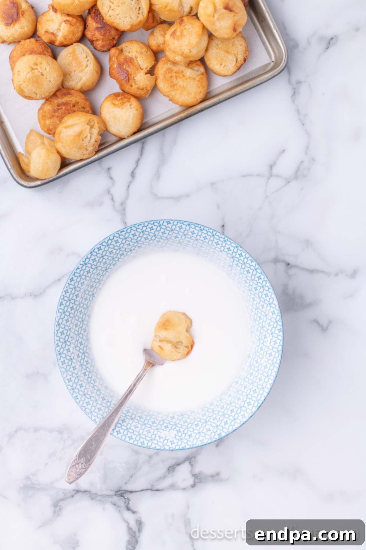 Krispy Kreme Donut Bites 18 A freshly fried donut hole being dunked into the warm, luscious glaze, ensuring full coverage.