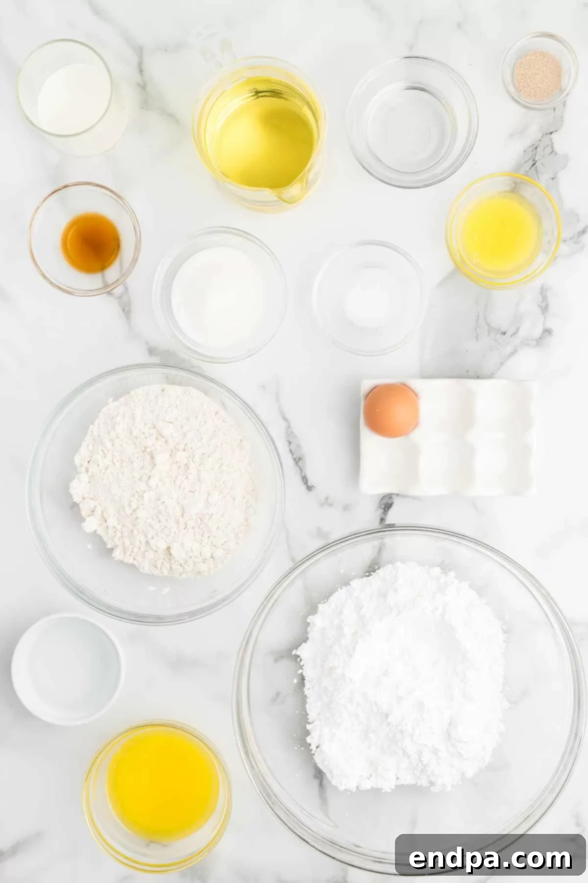 Krispy Kreme Donut Bites 3 A selection of key ingredients for Krispy Kreme donut holes: milk, boiling water, all-purpose flour, granulated sugar, butter, and vegetable oil, neatly arranged for the recipe.